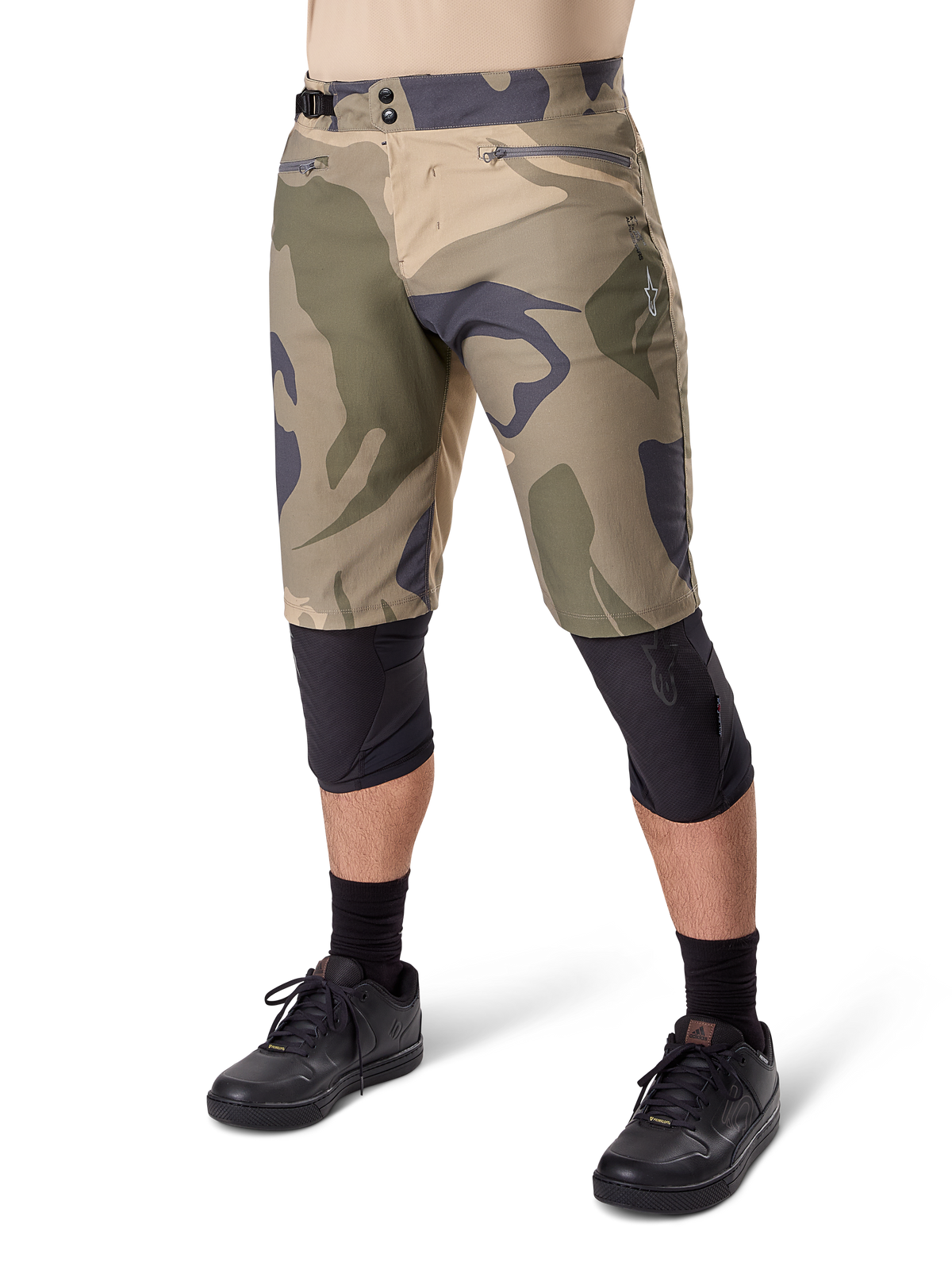Alpinestars A-Dura Camo Liner Short, MTB-shorts, brunt kamouflagemönster, frontvy som visar dragkedjeförsedda fickor och sidoreglering i midjan, bärs med svarta knäskydd och svarta cykelskor, hållbar utrustning för MTB