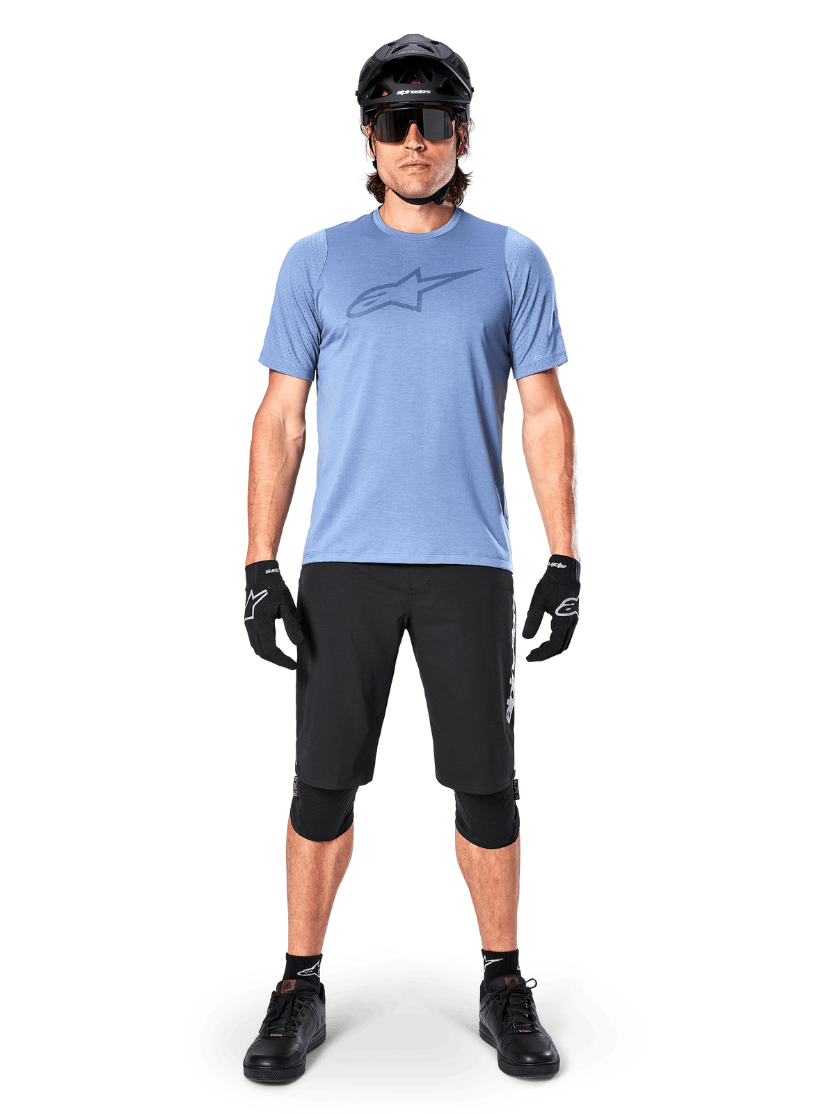 Alpinestars A-Dura Elite Shorts, Black Mountain Bike Shorts, worn with a light blue t-shirt, black helmet, sunglasses, and knee pads, professional off-road cycling apparel
