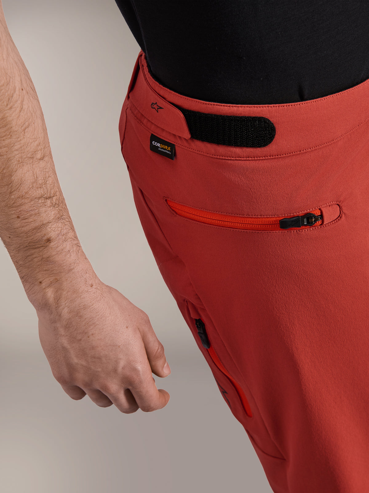 Alpinestars A-Dura Elite-shorts, mörkorange, närbild av sidoprofil med kardborrejustering i midjan, Cordura®-logotyp och sidoficka med dragkedja, premium mountainbikeshorts