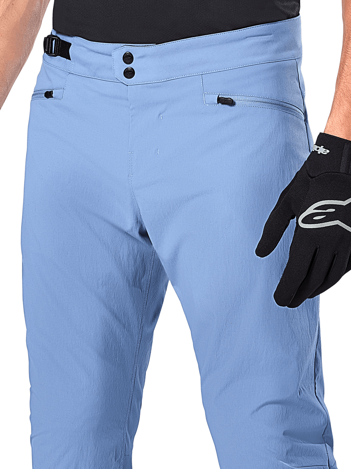 Alpinestars A-Dura-byxor, MTB-byxor, Infinity Blue, närbild på midjan med dubbel tryckknappsstängning och sidjustering, blixtlåsförsedda fickor, bärs med svarta Alpinestars-handskar