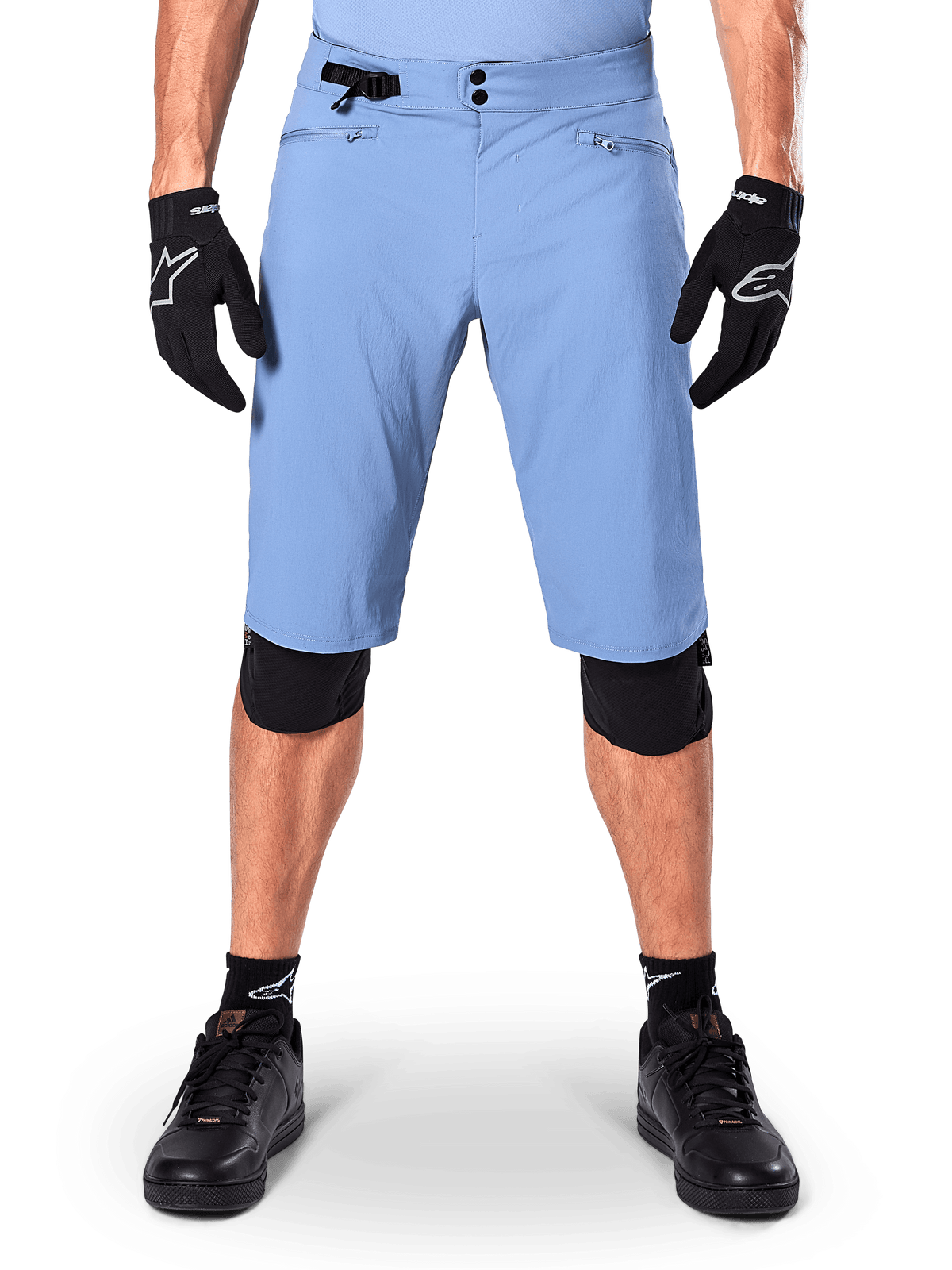 Alpinestars A-Dura Shorts, Infinity Blue mountainbikeshorts, bärs med svarta handskar och knäskydd, med dubbelknäppning och sidoreglering i midjan, teknisk cykelutrustning för MTB