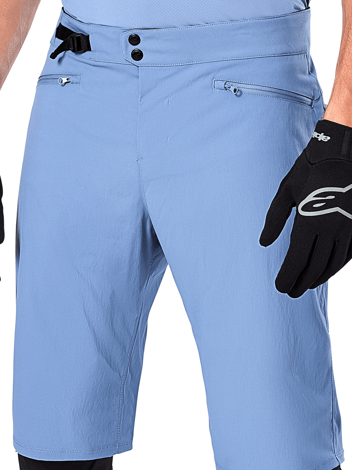 Alpinestars A-Dura Shorts, Infinity Blue mountainbikeshorts, närbild på midjan med dubbelknäppning, justerbart sidoreglage och dragkedjeförsedda nätfodrade fickor, bärs med en svart Alpinestars-handske