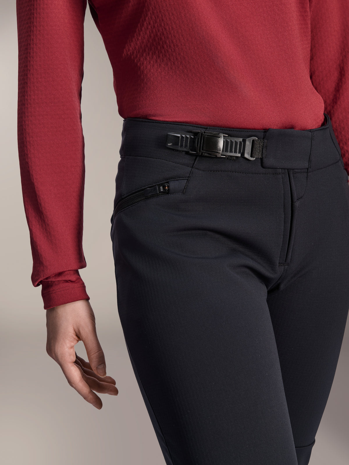 Alpinestars Stella A-Dura Thermal Pant, MTB-byxor för dam, svarta, närbild som visar spärrspännet i midjan och sidoficka med dragkedja, bärs med en mörkröd långärmad tröja, slitstark utrustning för stigcykling i kallt väder