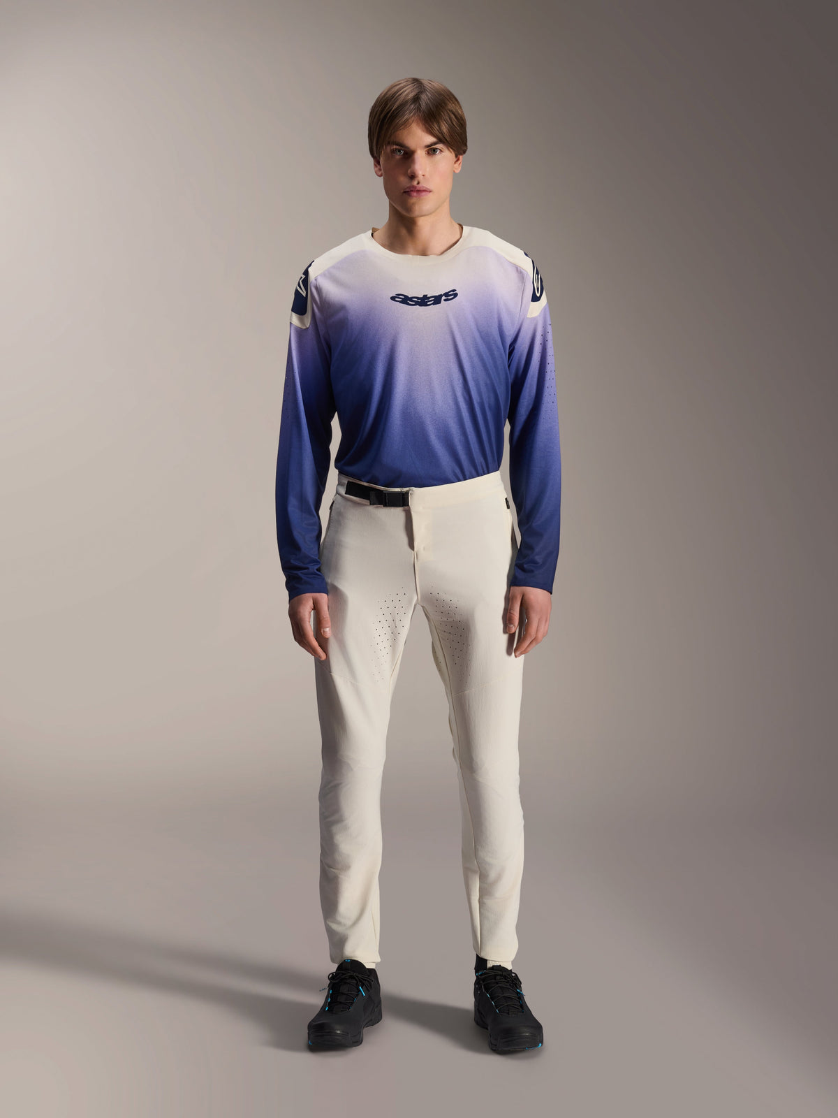 Alpinestars A-Aria Polartec Maker Elite Jersey, långärmad mountainbiketröja, tonad i Baja Blue och vitt, med astars-logotyp på bröstet, bärs av en modell med benvita byxor och svarta skor, prestandakläder för cykling