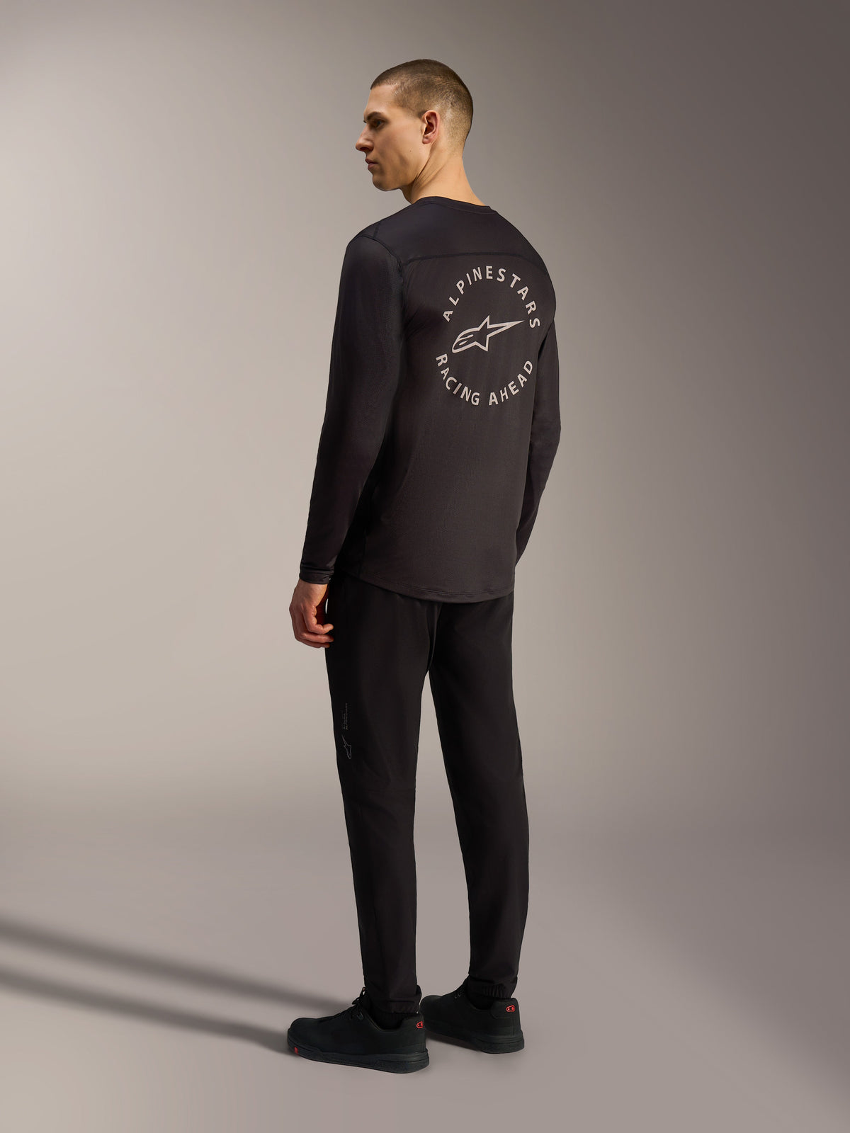 Svart Alpinestars A-Dura Air långärmad tröja med vit cirkulär Racing Ahead-grafik på ryggen, MTB-stil.