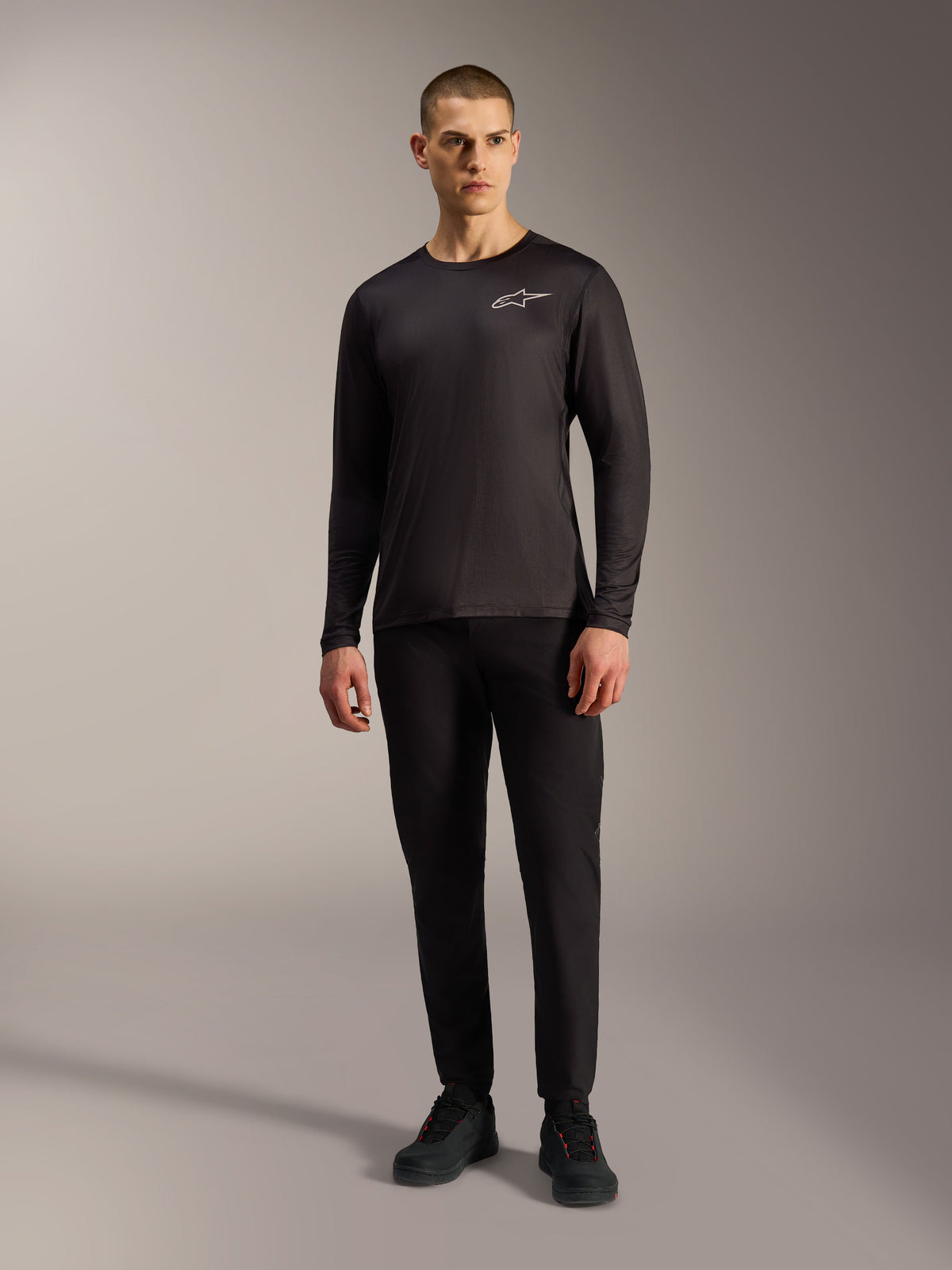 Svart A-Dura Air långärmad MTB-tröja med vit Alpinestars-logotyp på bröstet, buren av en manlig modell.