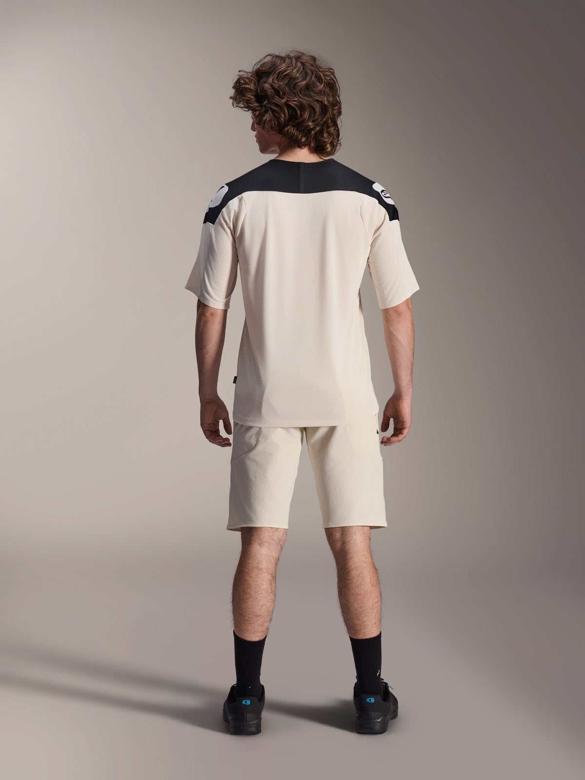 Alpinestars A-Aria Polartec Elite Short Sleeve Jersey, MTB Cycling Jersey, Ecru with black shoulder panels, back view shown with matching shorts and black socks, performance fit with a dropped tail design for off-road riding.