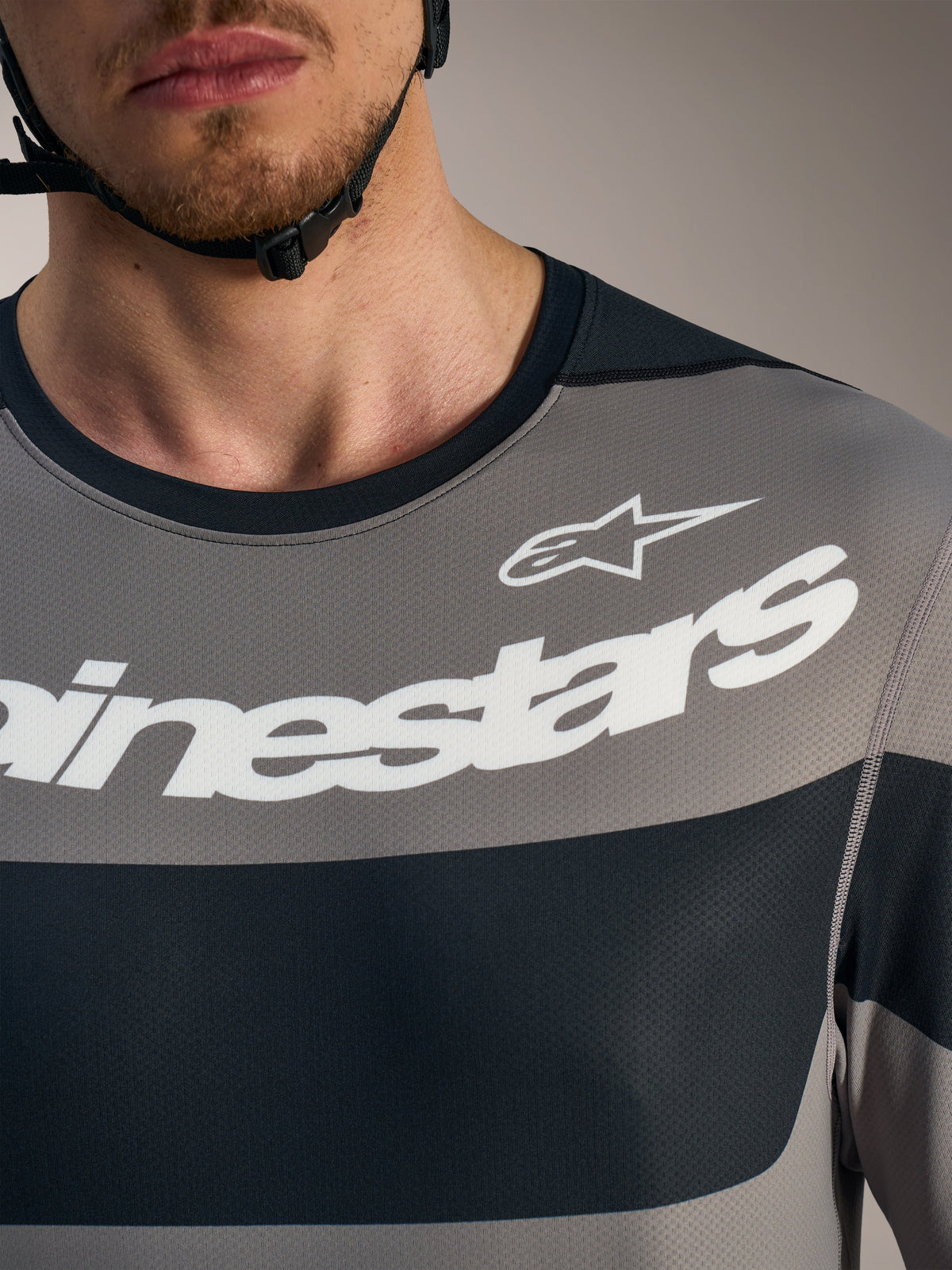 Grå A-Dura Race långärmad tröja med vita Alpinestars-logotyper och ventilerande tekniskt meshtyg.