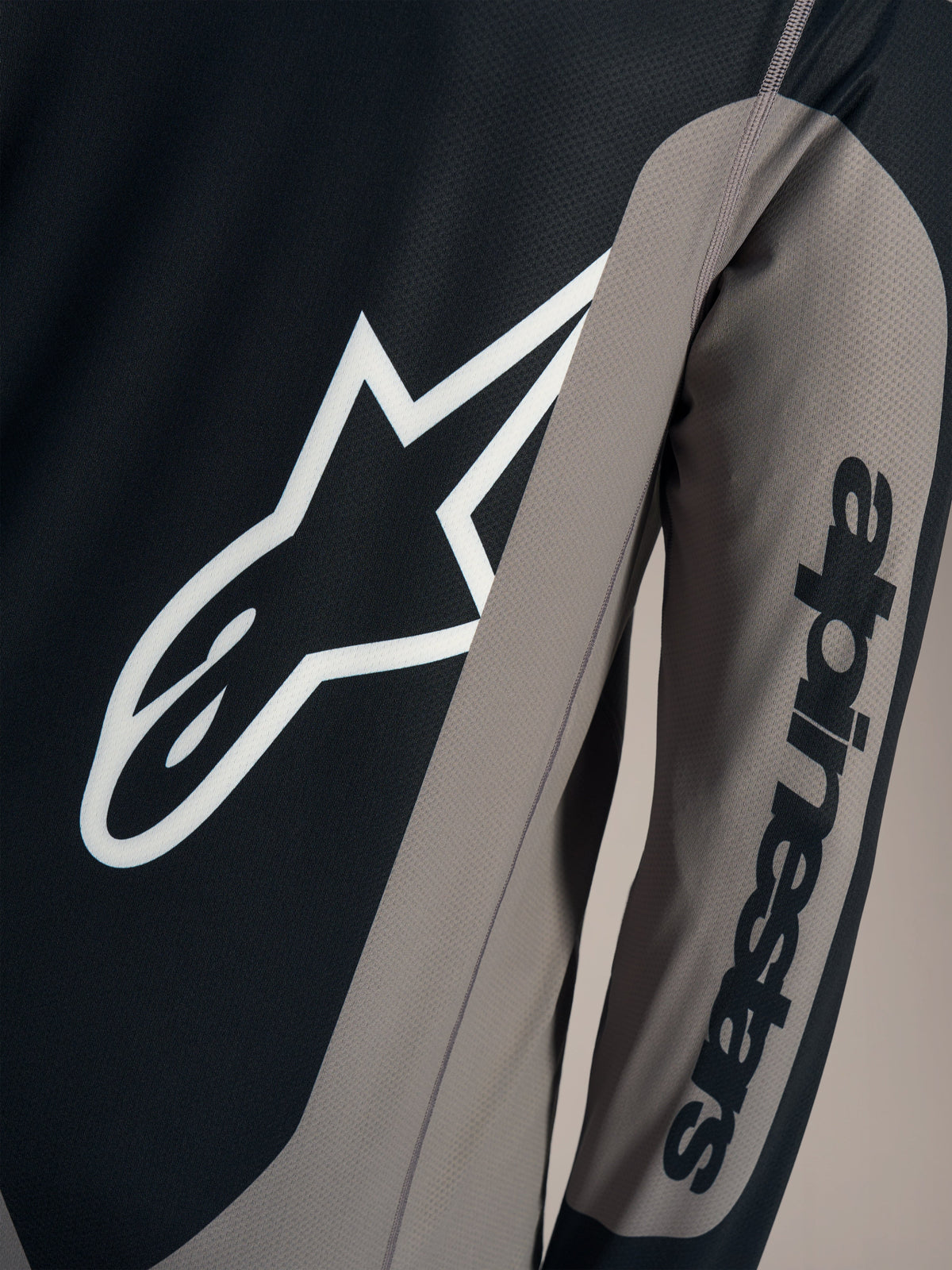 Grå A-Dura Race långärmad tröja med vit Astars-logotyp på bröstet och Alpinestars-ordmärke på ärmen.