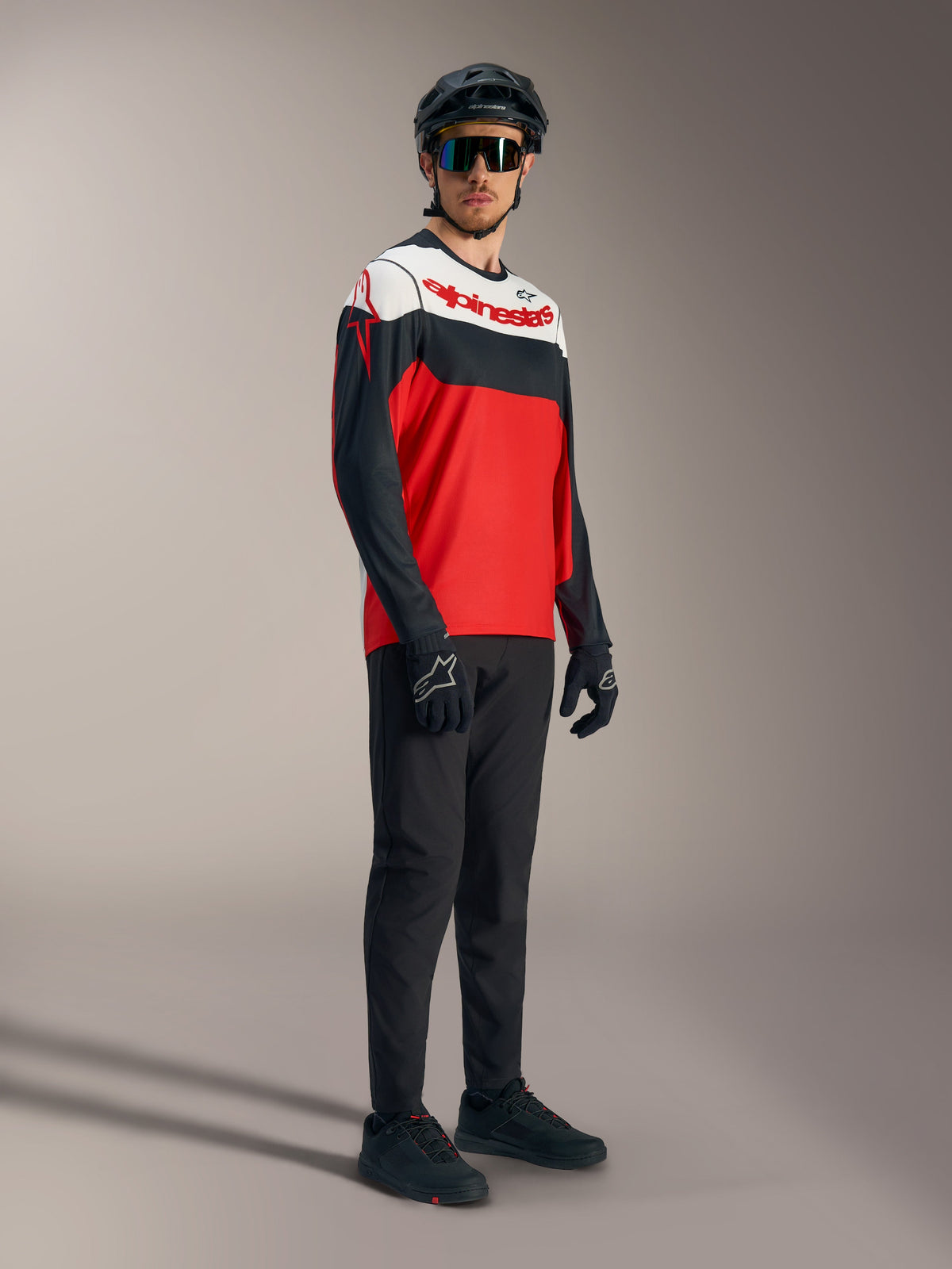 A-Dura Race långärmad tröja i rött, svart och vitt med tydliga logotyper, stylad med professionell mountainbikeutrustning.