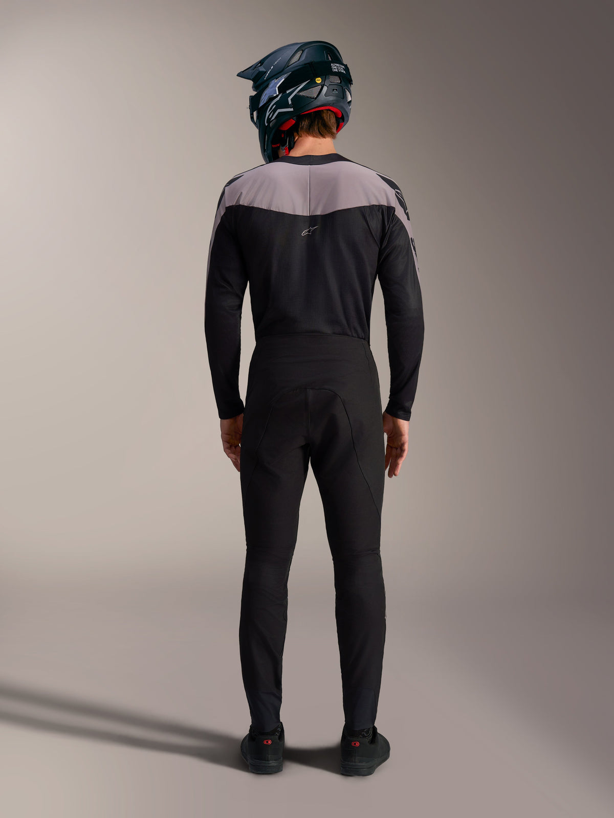 Alpinestars A-Supra Elite MTB-kit i svart med performance-byxor, tröja och fullfacehjälm, vy bakifrån.