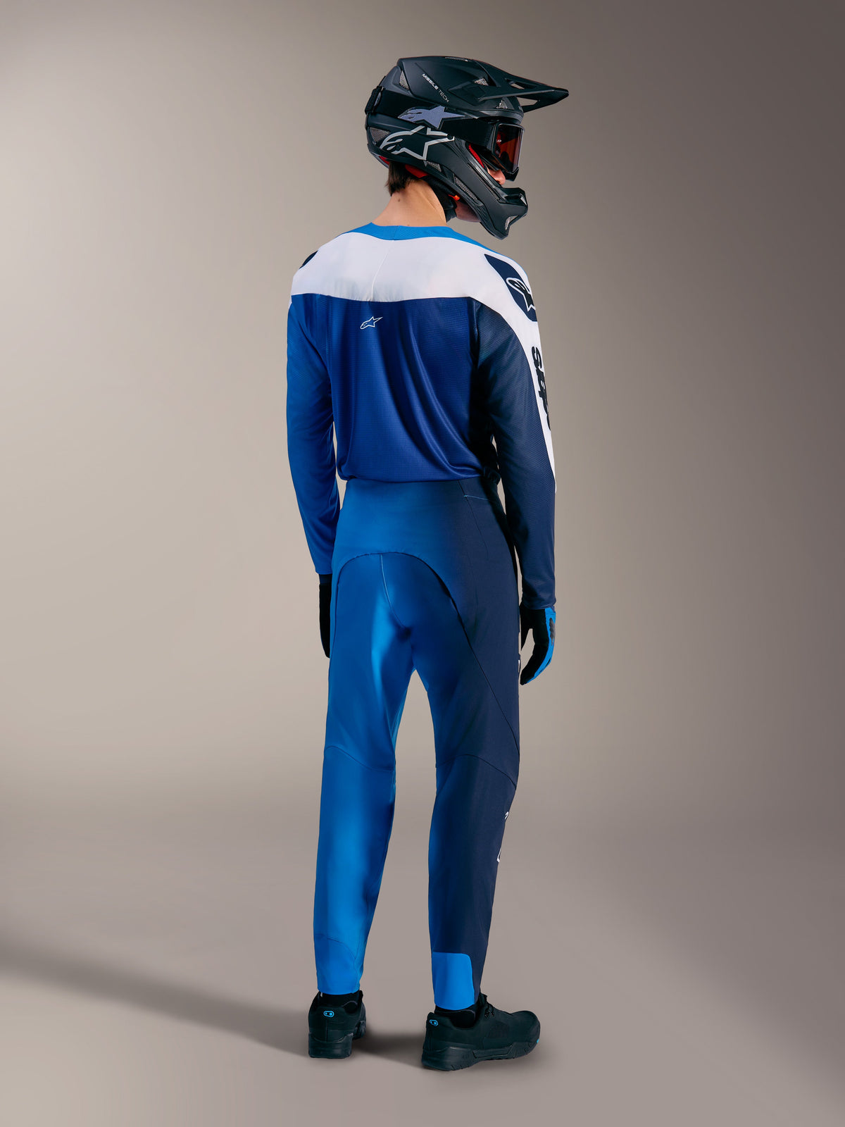 A-Supra Elite MTB-utrustning i Faded Bright Blue, med matchande tröja och byxor sedda bakifrån samt en fullface-hjälm.