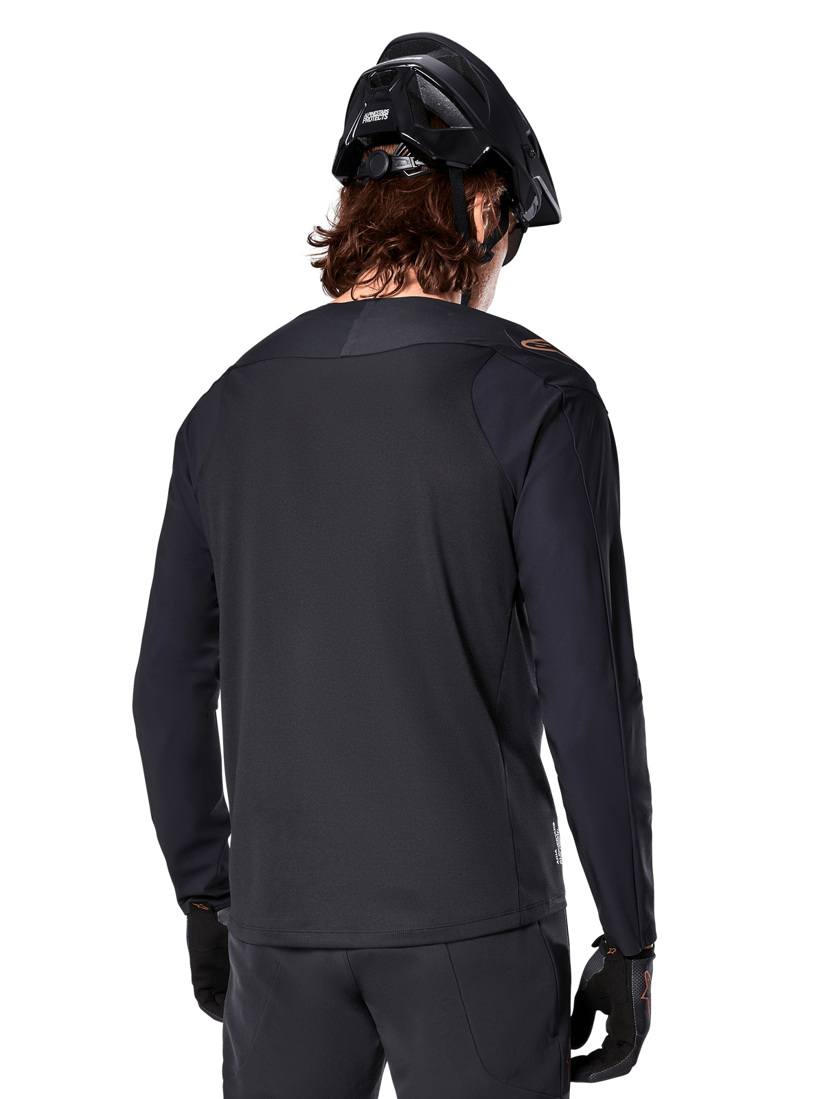 Alpinestars A-Aria Polartec Switch tröja, långärmad, svart, vy bakifrån, bärs tillsammans med en svart MTB-hjälm och handskar, med förlängd rygg för prestanda i terräng