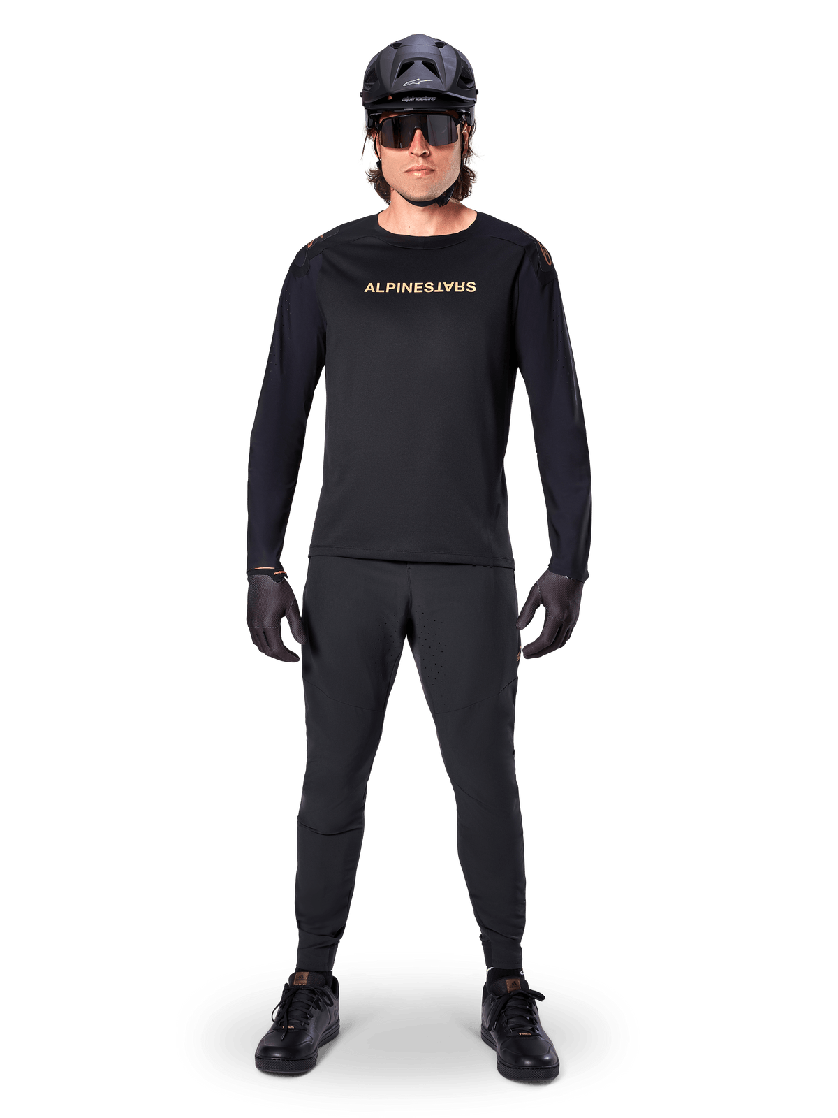 Alpinestars A-Aria Polartec Switch långärmad tröja, svart, bärs av en cyklist med matchande svarta tekniska byxor, svart hjälm, solglasögon och svarta handskar, prestanda-MTB-utrustning för terrängstigar