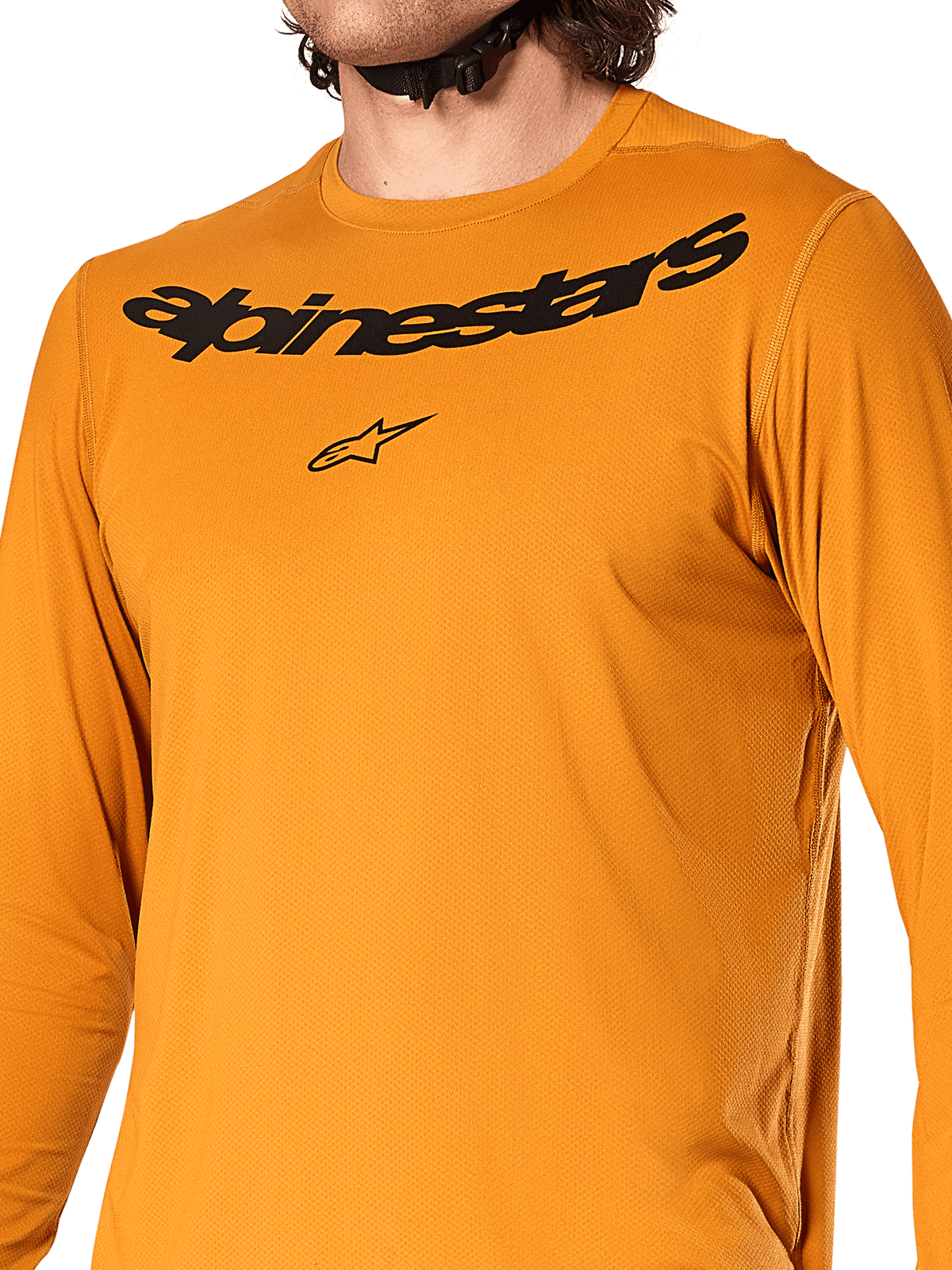 Alpinestars A-Dura Rocker Long Sleeve Jersey, Dark Gold, close-up view of chest featuring black Alpinestars wordmark and star logo, textured jacquard moisture-wicking fabric, performance MTB cycling apparel