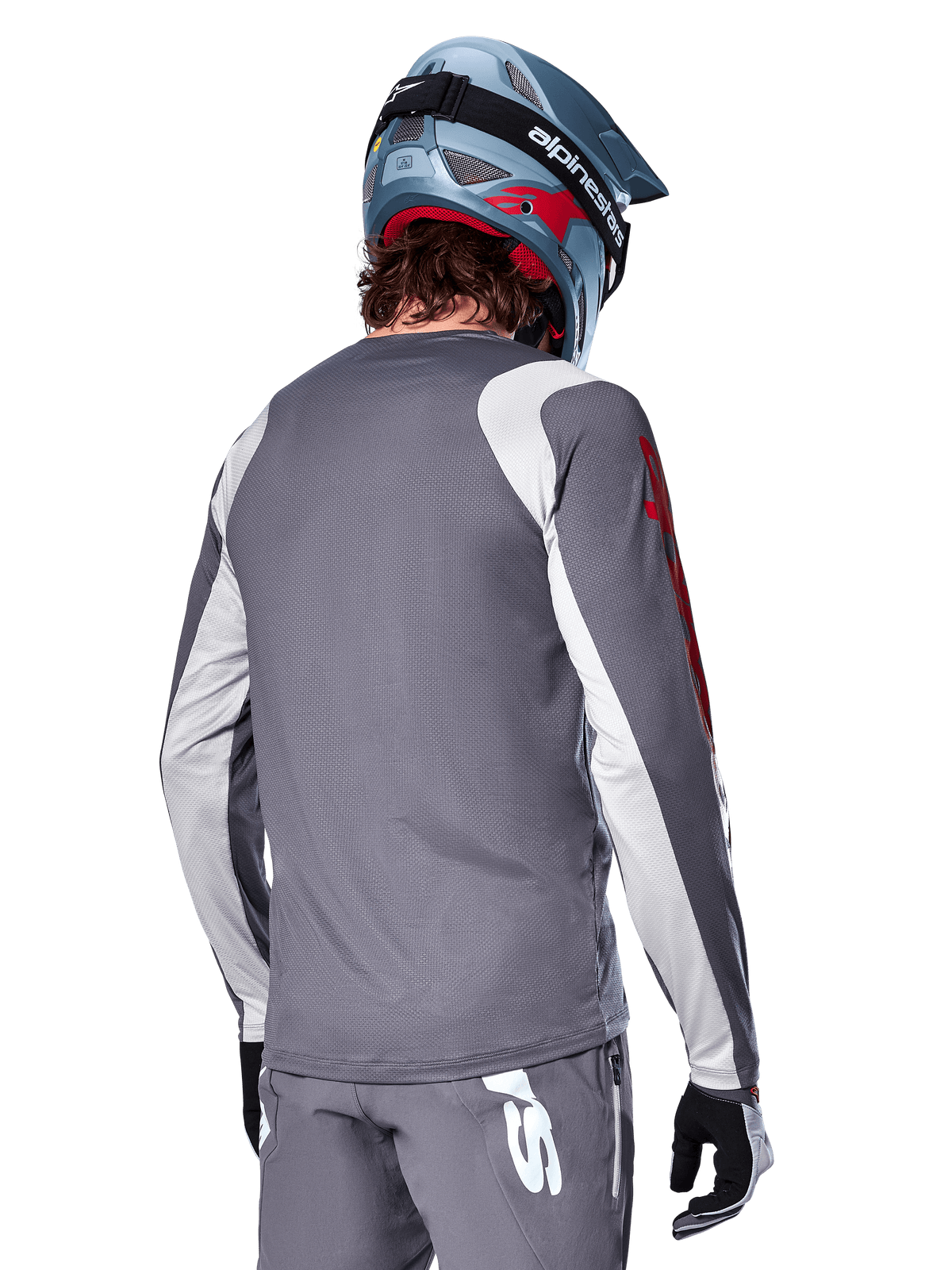 Alpinestars A-Supra Astar Long Sleeve Jersey, Dark Gray with light gray shoulder and arm panels, rear view of rider wearing a blue full-face mountain bike helmet and gray pants, performance-fit MTB cycling apparel