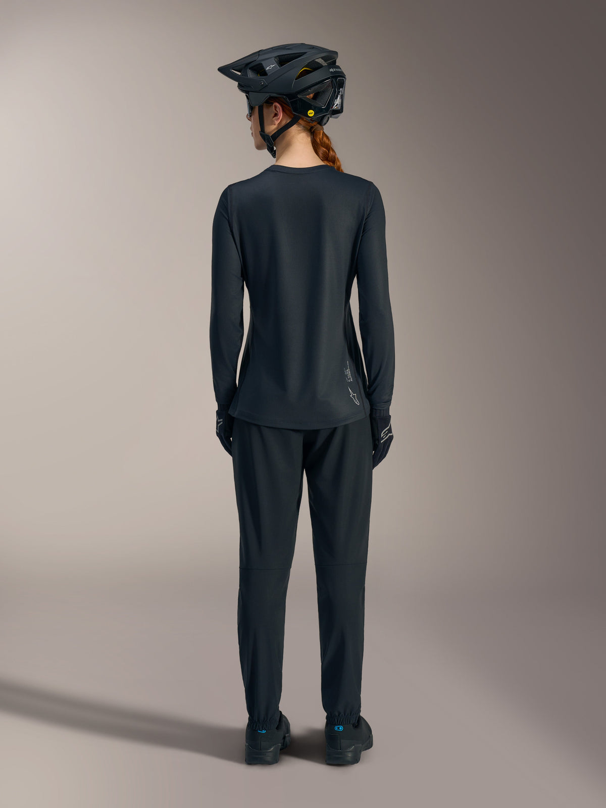Women’s black Stella A-Dura Ride Long Sleeve MTB Jersey, back view featuring a dropped tail and white Alpinestars logo.
