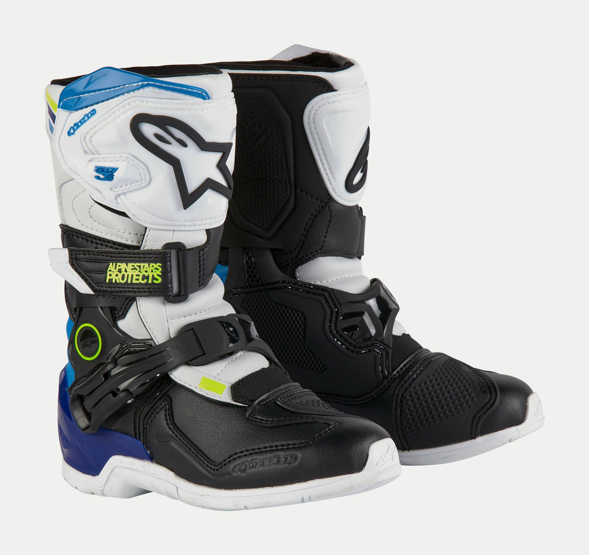Alpinestars Tech 3S barnstövlar, motocross-stövlar för barn, vita, svarta och emaljblå, med vita och svarta skyddspaneler, blå detaljer på hälen och upptill, neongul logotyp och ett säkert spännsystem.