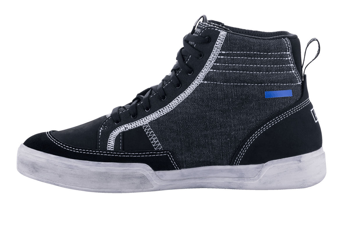 Alpinestars Ageless motorskor, svarta och grå motorcykelskor, sedda från sidan, konstruktion i canvas och mocka med vita kontrastsömmar, high-top sneaker-stil med benvit sula och svarta skosnören.