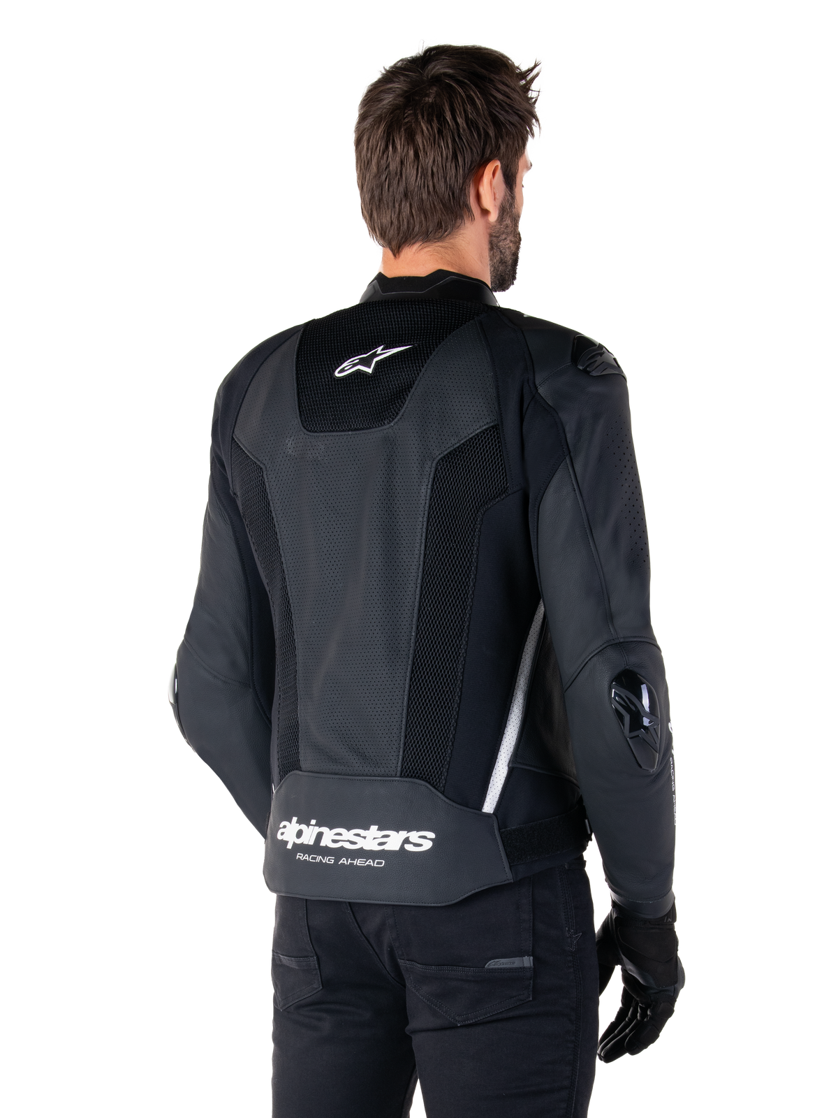 Alpinestars Missile V3 Airflow läderjacka, svart och vit, vy bakifrån med perforerat läder och meshpaneler för maximal ventilation, vit Alpinestars-logotyp på nedre ryggen och stjärnlogotyp i nacken, bärs med svart MC-utrustning, förstklassig racingdesign.