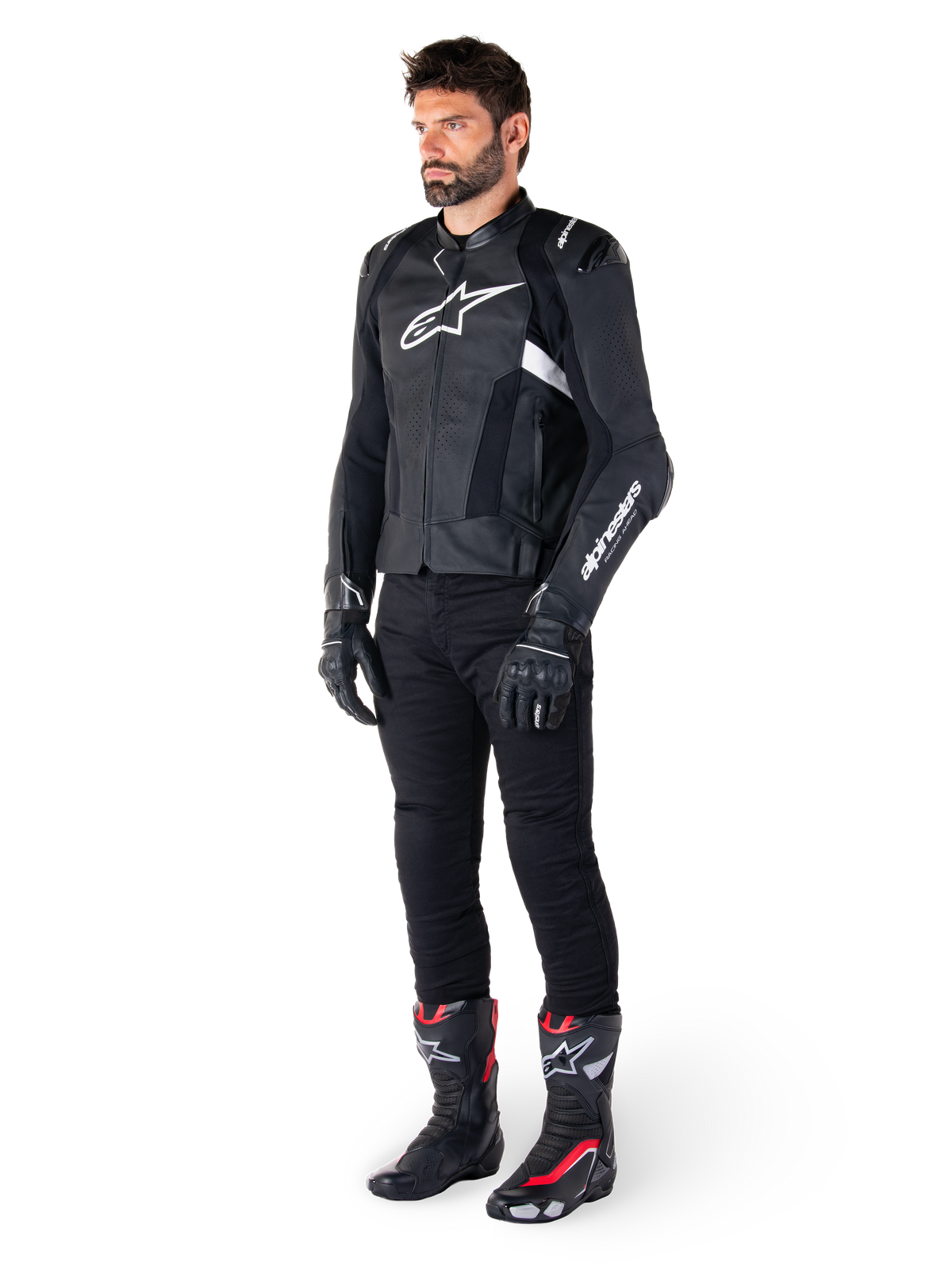 Alpinestars Missile V3 Airflow läderjacka, svart och vit, bärs av en manlig modell med svarta körbyxor, svarta handskar och racingstövlar med röda och vita detaljer, med perforerat läder och vit logotyp, prestandainriktad racingutrustning för motorcykel