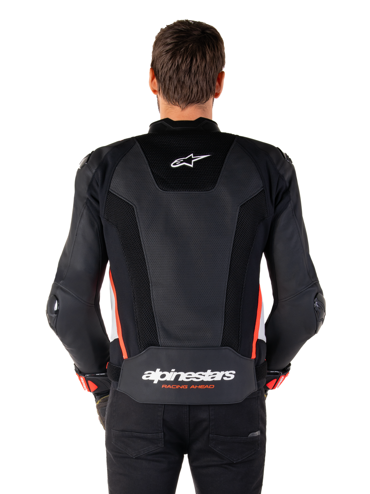 Ryggvy av en person som bär Alpinestars Missile V3 Airflow-läderjacka i färgen Black White Red Fluo, med omfattande perforerade läderpaneler för ventilation, en liten Alpinestars-logotyp på övre ryggen och framträdande 'alpinestars RACING AHEAD'-profilering i midjan.