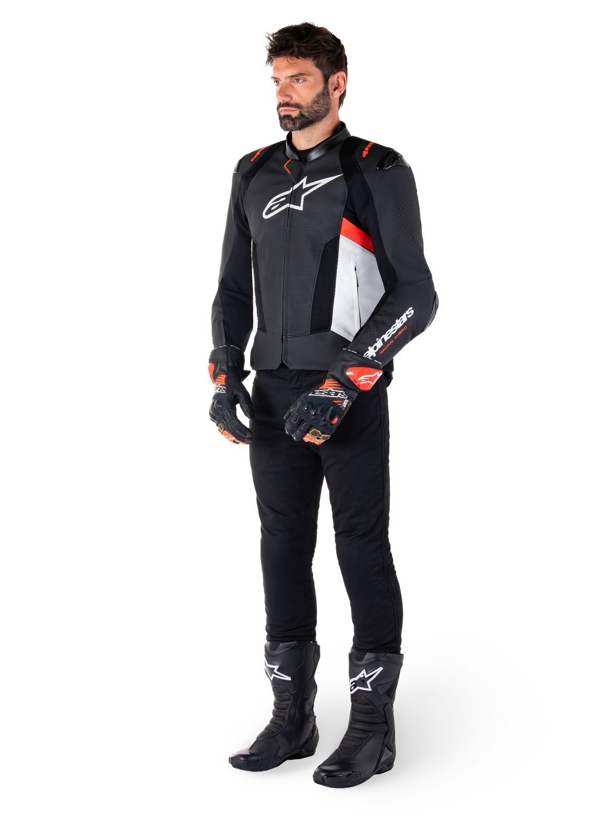 Alpinestars Missile V3 Airflow läderjacka, i färgerna svart, vit och röd fluo, bärs av en manlig modell med svarta byxor, svarta racinghandskar och svarta stövlar, med perforerat läder för ventilation, vit logotyp på bröstet och röd fluo-detaljer, designad för förstklassig racing och sportprestanda.
