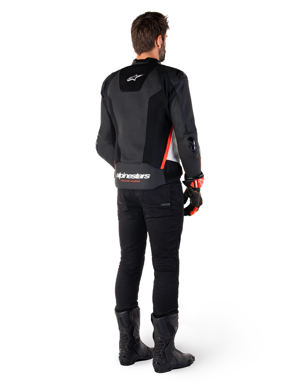 Förare sedd bakifrån som bär Alpinestars Missile V3 Airflow läderjacka i svart, vitt och fluorescerande rött, kombinerad med svarta byxor och svarta stövlar, med omfattande perforerat läder för ventilation, DFS-axelskydd och tydlig Alpinestars-logotyp på nedre delen av ryggen.