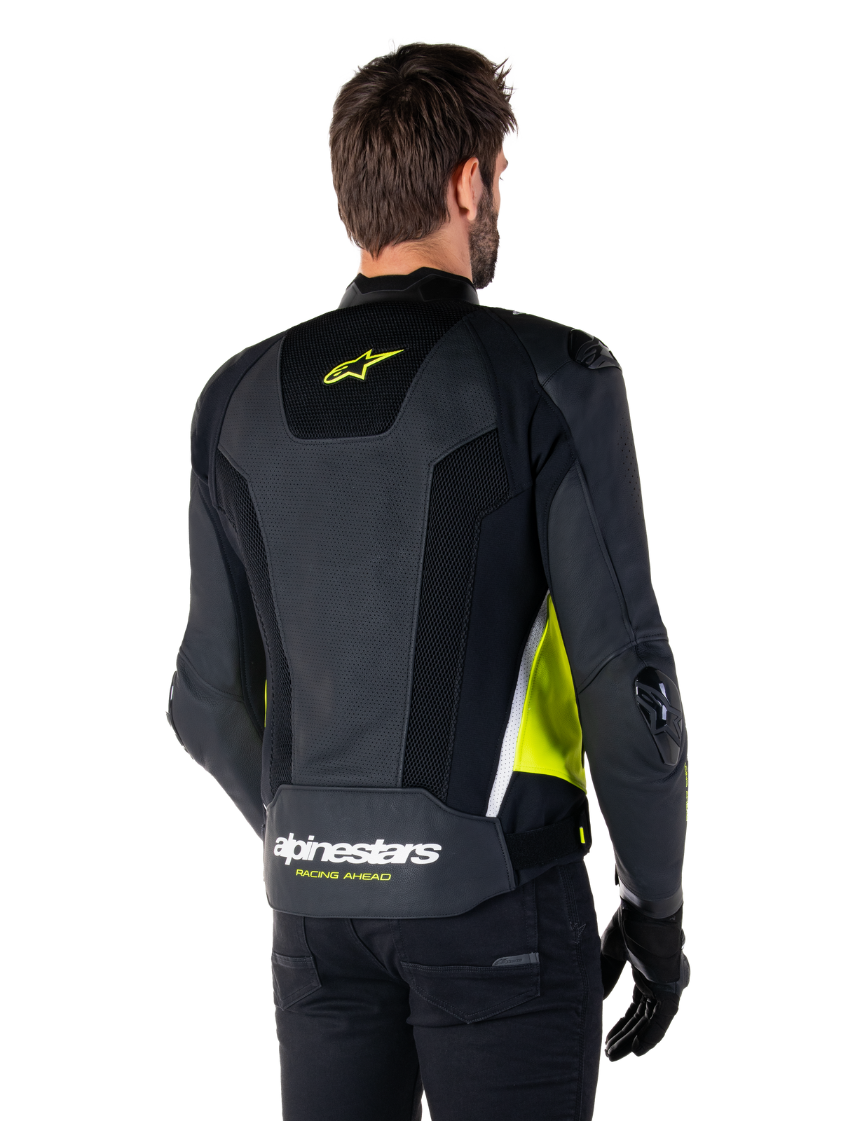Alpinestars Missile V3 Airflow läderjacka, baksida på manlig modell, svart med fluorescerande gula och vita detaljer, omfattande perforerat läder och meshpaneler på ryggen, gul stjärnlogotyp och vit 'RACING AHEAD'-text, svarta handskar och byxor