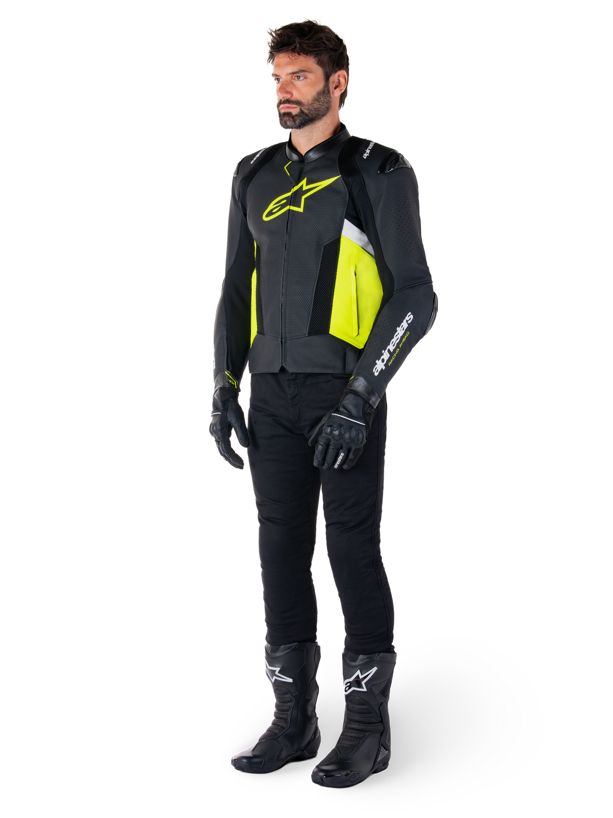 Manlig modell iklädd Alpinestars Missile V3 Airflow Läderjacka i svart, gul fluo och vitt, stylad med svarta körhandskar, byxor och stövlar, vilket framhäver den perforerade läderdesignen och den racinginspirerade estetiken.