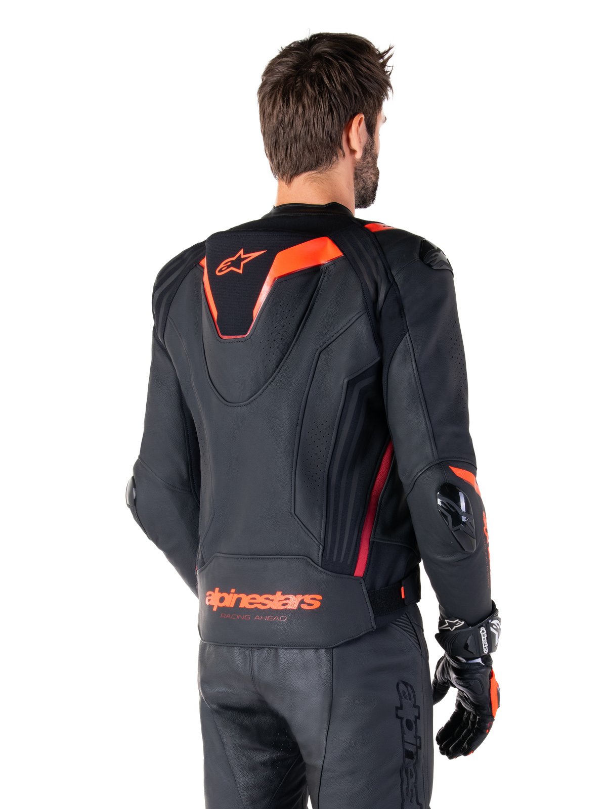 Alpinestars Missile V3 Ignition läderjacka, racingsportjacka för herrar, svart med Red Fluo-detaljer, vy bakifrån som visar den smala aerodynamiska puckeln och Alpinestars-logotyp på nedre delen av ryggen, bärs med svarta läderbyxor och racinghandskar, stilren professionell motorsportdesign