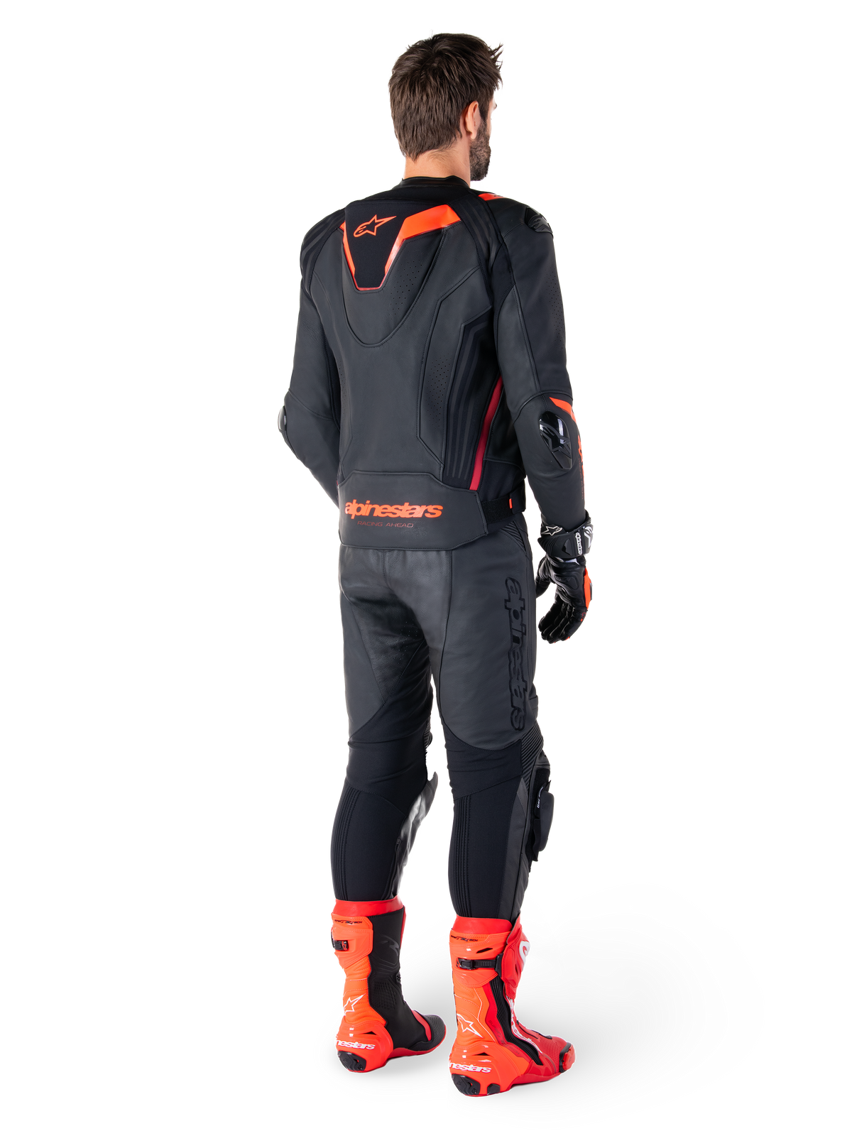 Alpinestars Missile V3 Ignition Leather Jacket, Racing Sport Motorcycle Jacket, Black and Red Fluo, rear view of a rider wearing a full racing outfit with matching leather pants, gloves, and red boots, featuring a sport Aero-hump and bold branding on the lower back.