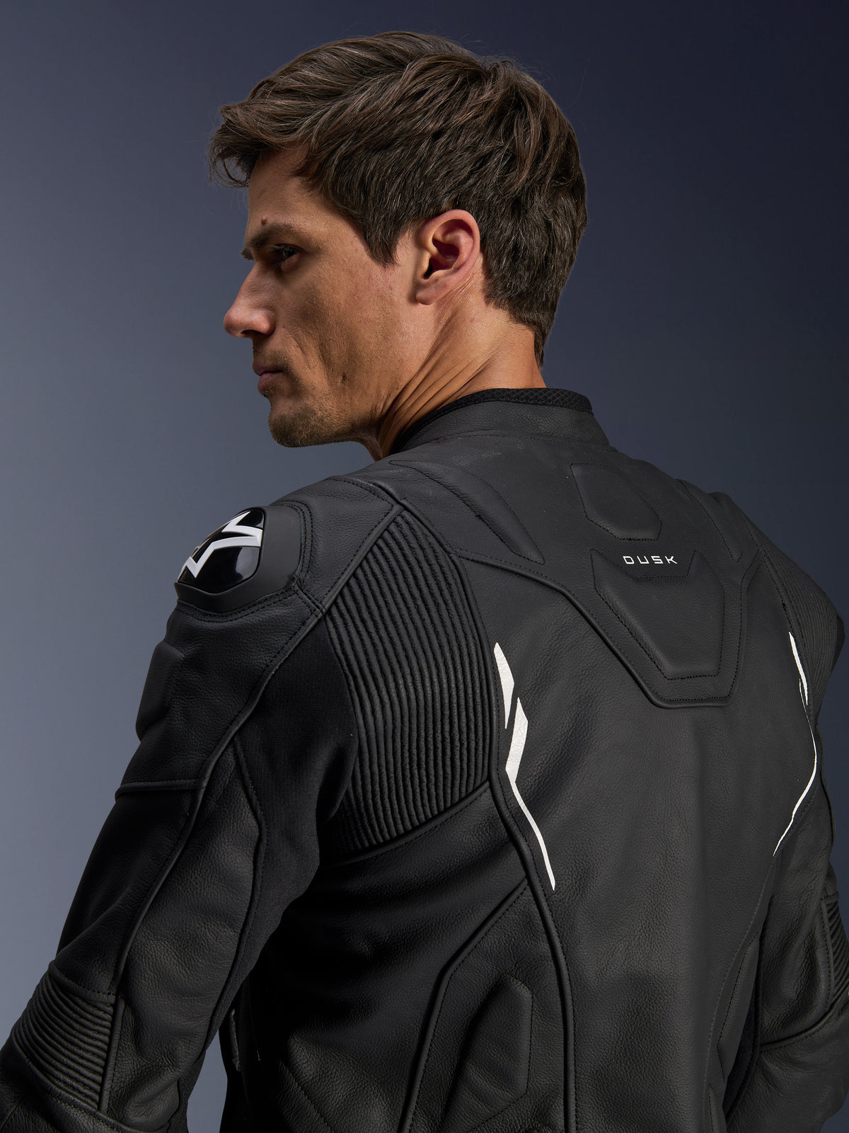 Alpinestars Dusk skinnjacka för herrar, svart och vit motorcykeljacka i nötläder med DFS-axelskydd, sedd bakifrån.