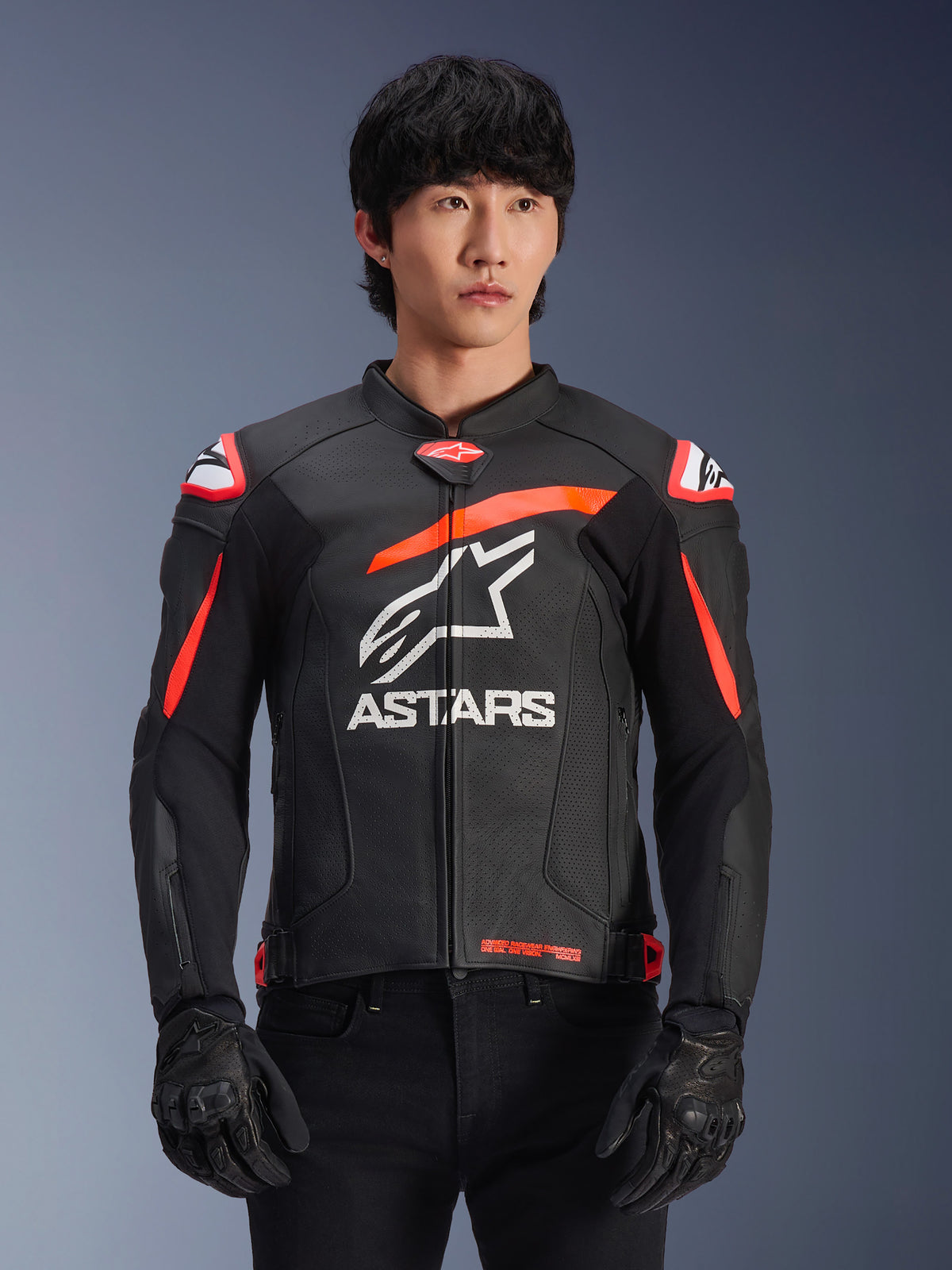 Alpinestars GP Plus R V4 Airflow skinnjacka, svart med fluoröda och vita detaljer, bärs av en modell, perforerad läderkonstruktion, stor vit ASTARS-logotyp på bröstet, integrerat axelskydd för motorcykelracing