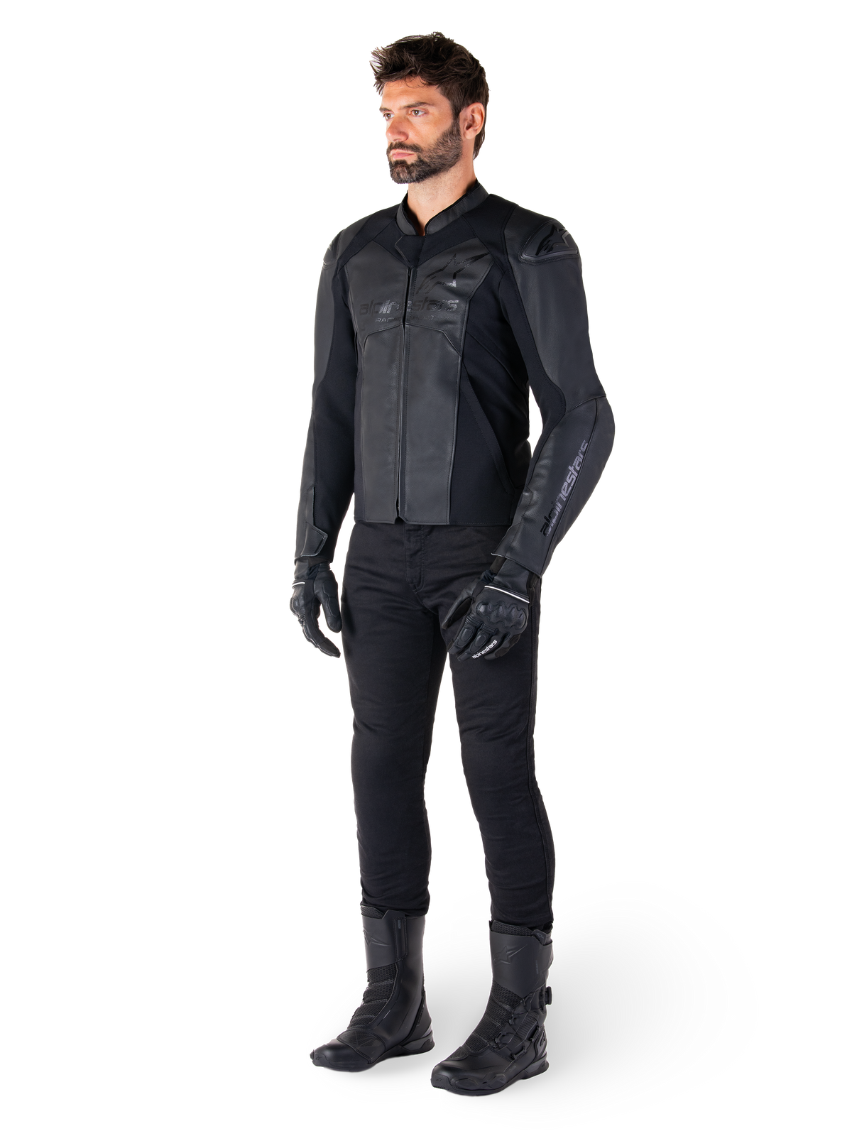 Alpinestars Faster V3 läderjacka, helsvart, bärs med svarta byxor, handskar och stövlar, med en teknisk läderkonstruktion, HRSF-stretchpaneler, integrerade DFS GP Lite-axelskydd och en stilren sportig silhuett.