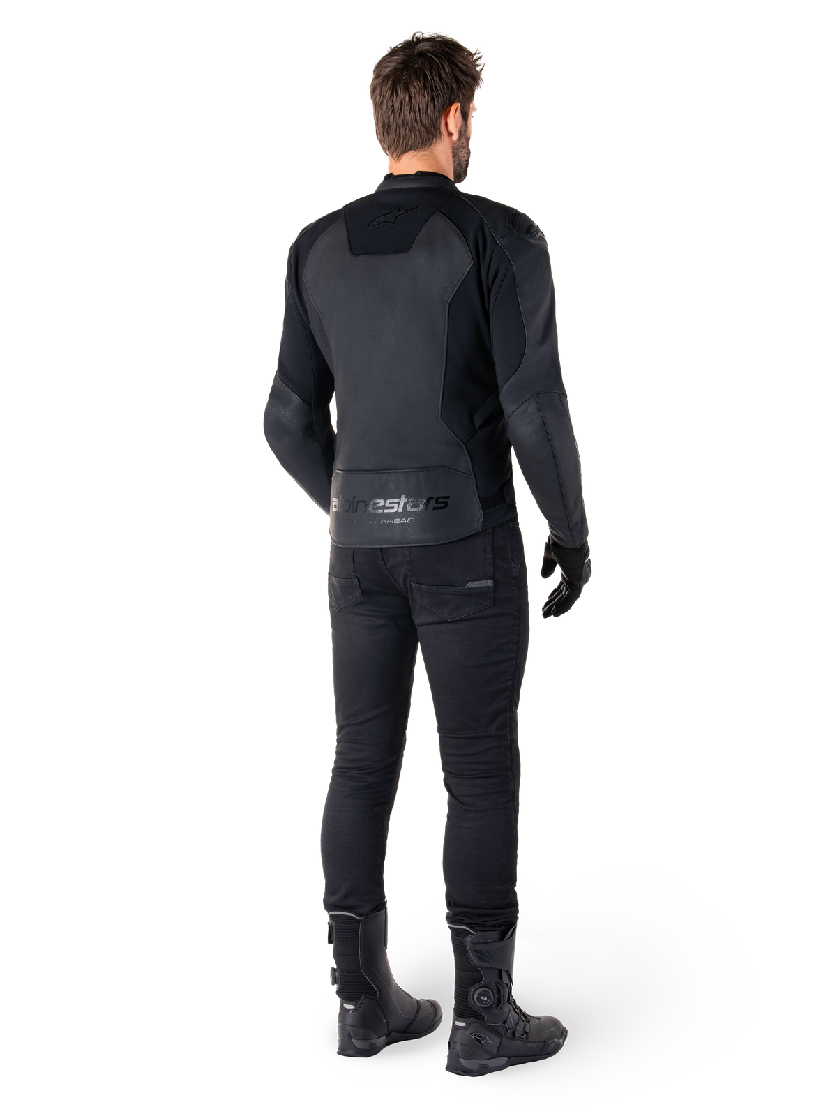 Alpinestars Faster V3 läderjacka, Black Black, bakifrån på en förare, med paneler i premiumläder och präglad Alpinestars-logotyp, kombinerad med svarta mc-byxor och stövlar för en komplett sportig motorcykel-look.