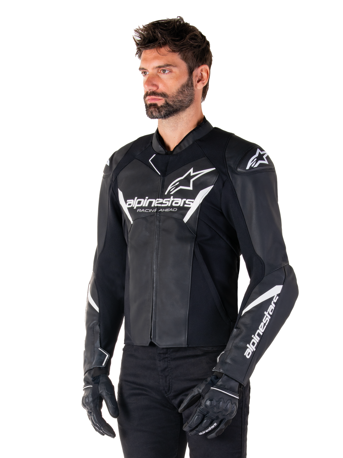 Alpinestars Faster V3 skinnjacka, sportjacka för motorcykelkörning, svart och vit, framträdande vit Alpinestars-logotyp och 'Racing Ahead'-text på bröstet, stjärnlogotyper på axlarna, premium läderkonstruktion med stretchpaneler, bärs av en modell med svarta byxor och handskar