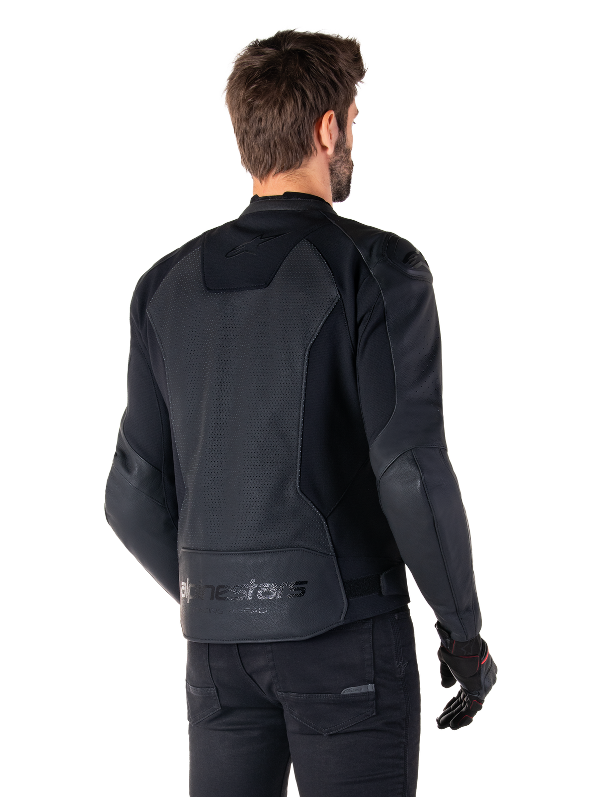 Alpinestars Faster V3 Airflow läderjacka, svart, ryggvy av en man som bär en sportig MC-jacka i läder med perforerade ryggpaneler, stretchinsatser och Alpinestars-märkning på den nedre fållen, kombinerad med svarta byxor och handskar
