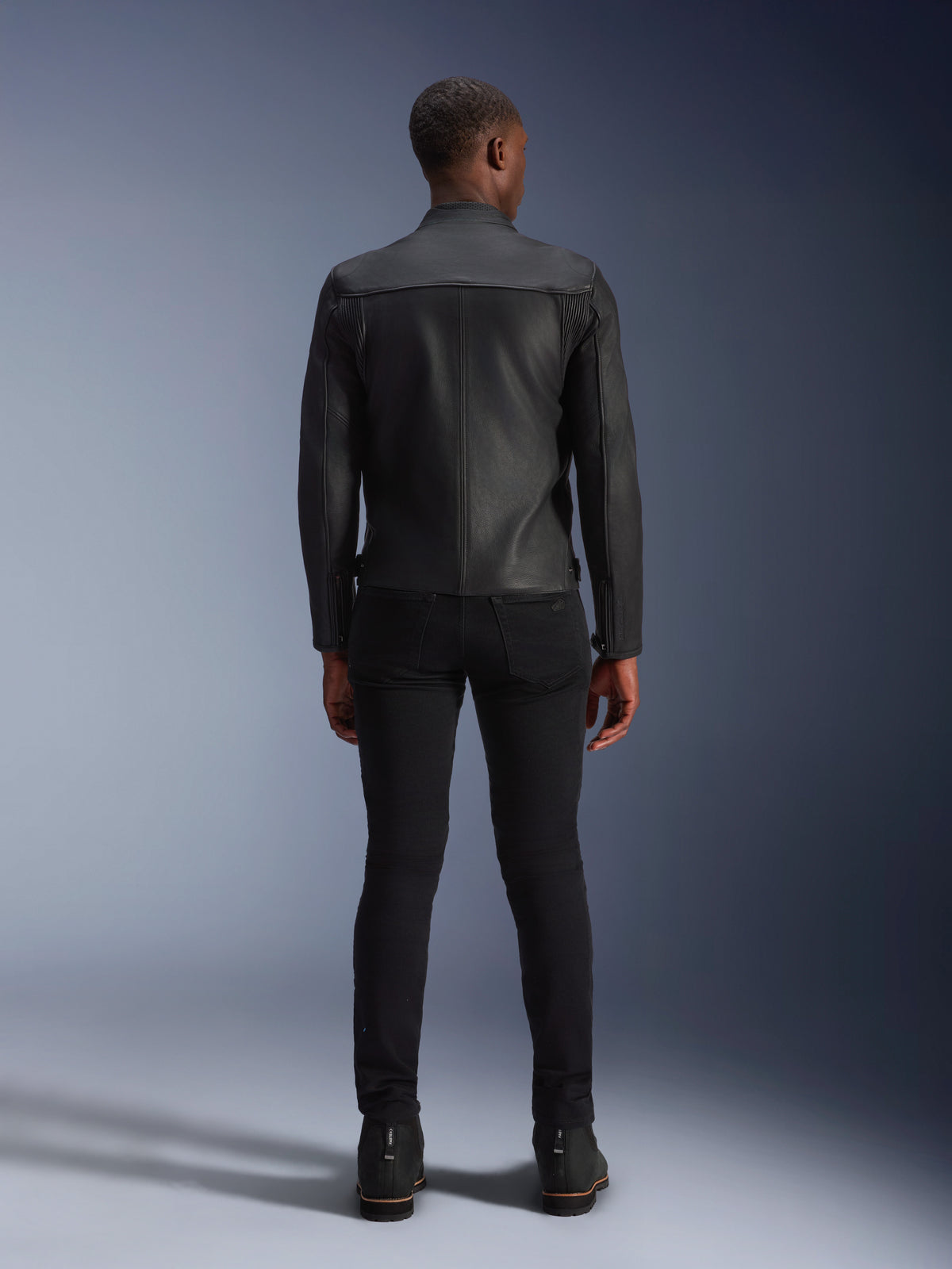 Alpinestars Blacktrack läderjacka för herrar, vy bakifrån, svart nötläder med dragspelspaneler för urban körning.