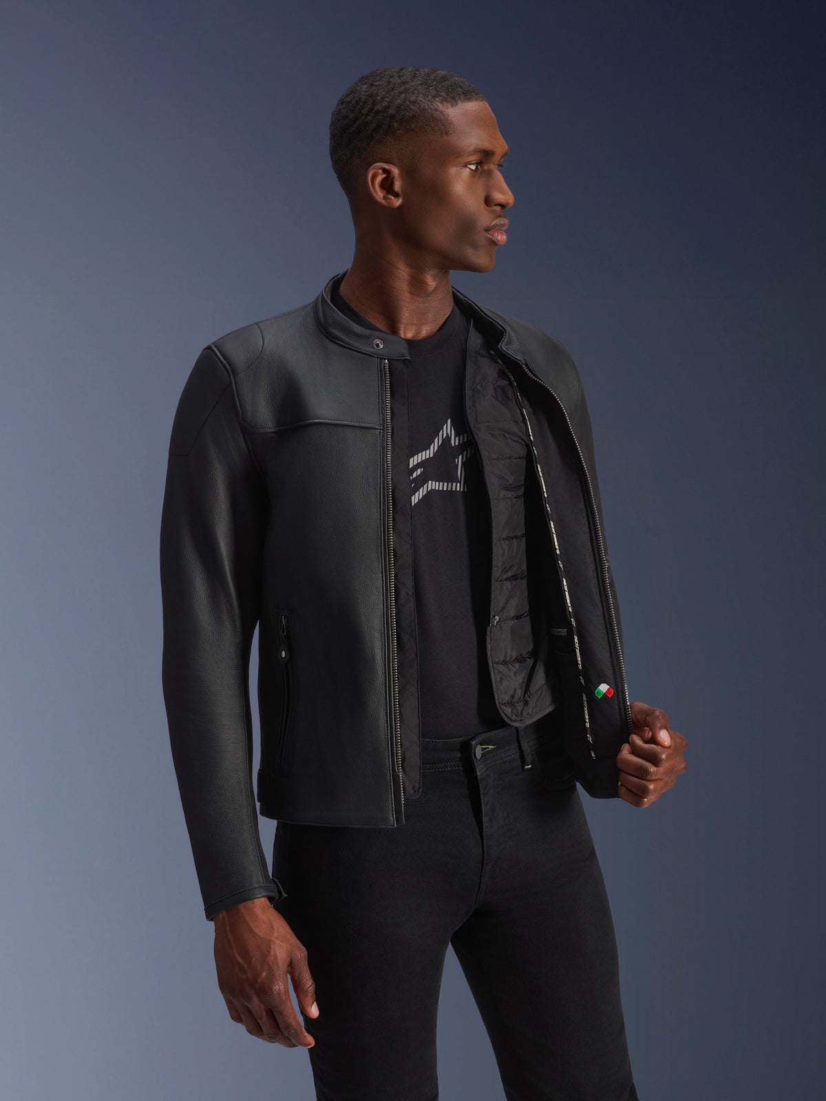 Alpinestars Blacktrack skinnjacka, svart nötläder, bärs av modell med öppen dragkedja och synlig termoväst.