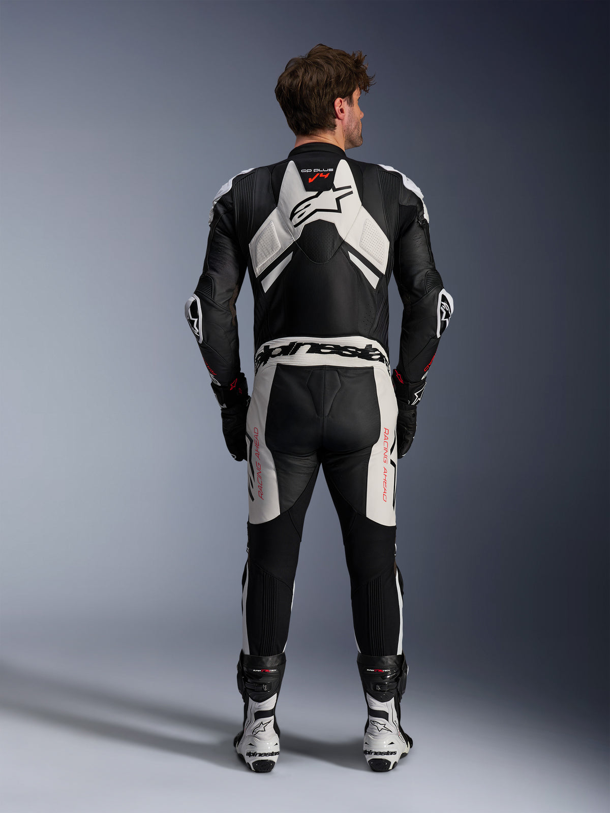 Alpinestars GP Plus V4 Sprint skinnställ, motorcykelracingställ för herr, svart, vit och röd fluo, vy bakifrån med aerodynamisk puckel, läder.