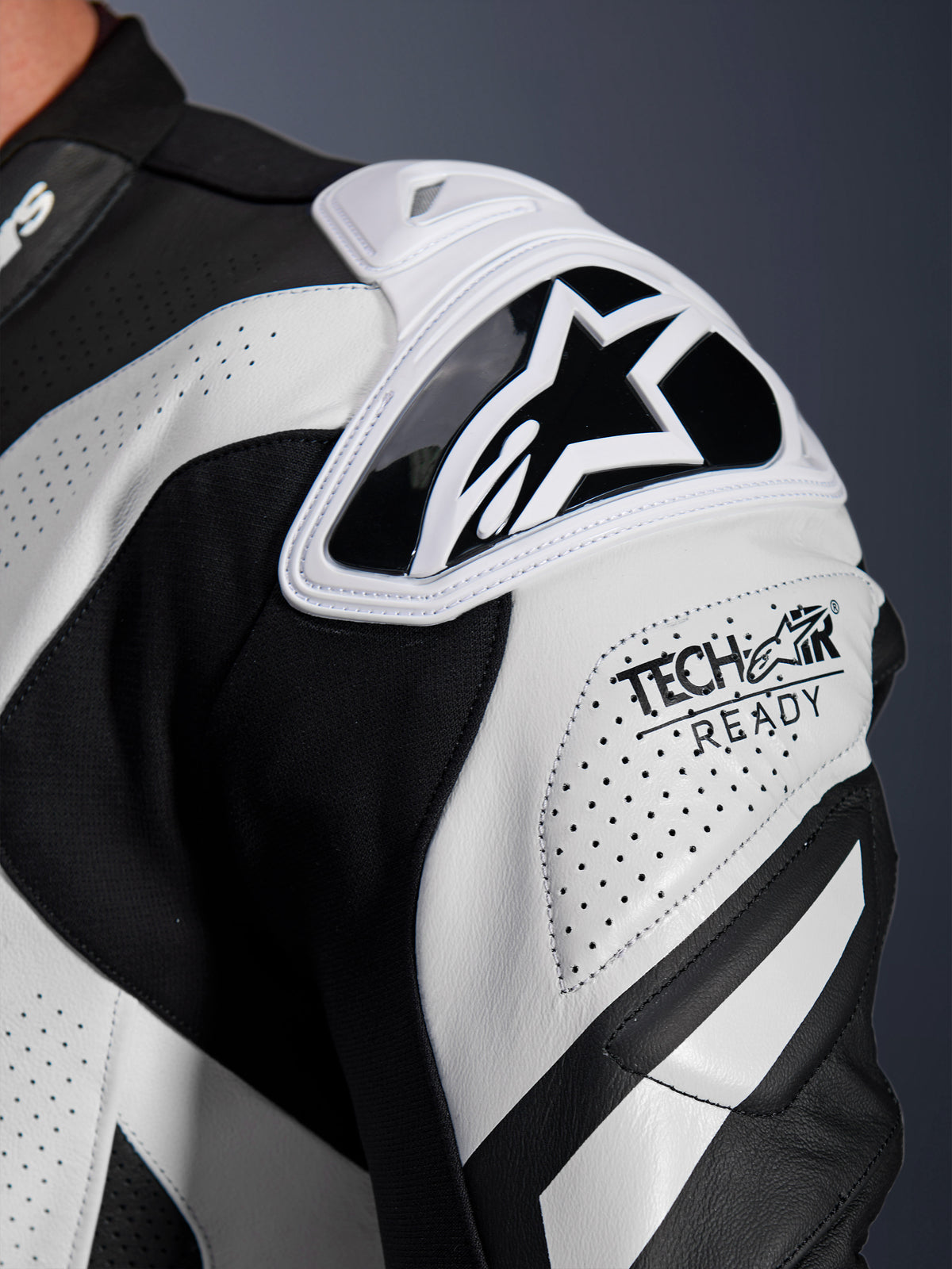 Alpinestars GP Plus V4 Sprint skinnställ, axelskydd i svart och vitt perforerat läder med Tech-Air Ready-logotyp.
