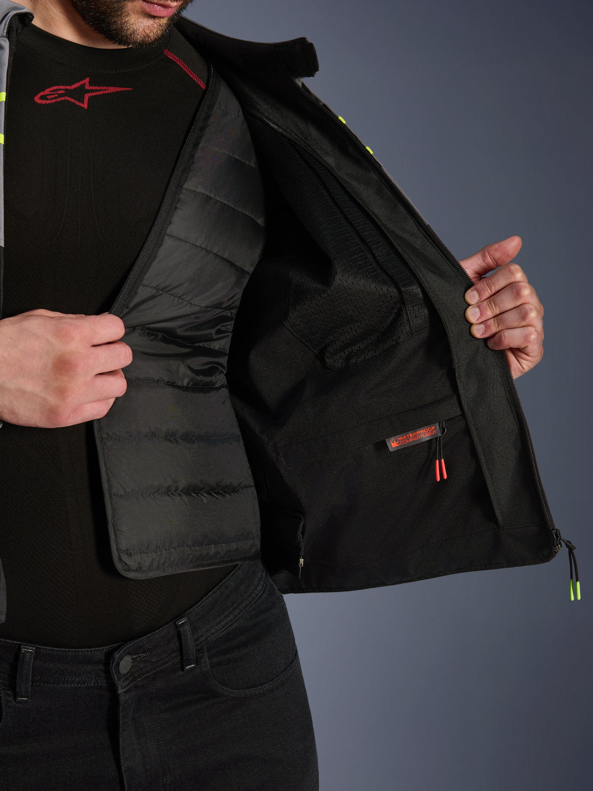 Alpinestars T-Jaws V4 Waterproof Jacket interiörvy, som visar det urtagbara svarta kviltade termofodret och ett vattentätt innerfack med röd etikett, med meshfoder och premiumkonstruktion av skyddsutrustning för motorcyklar.