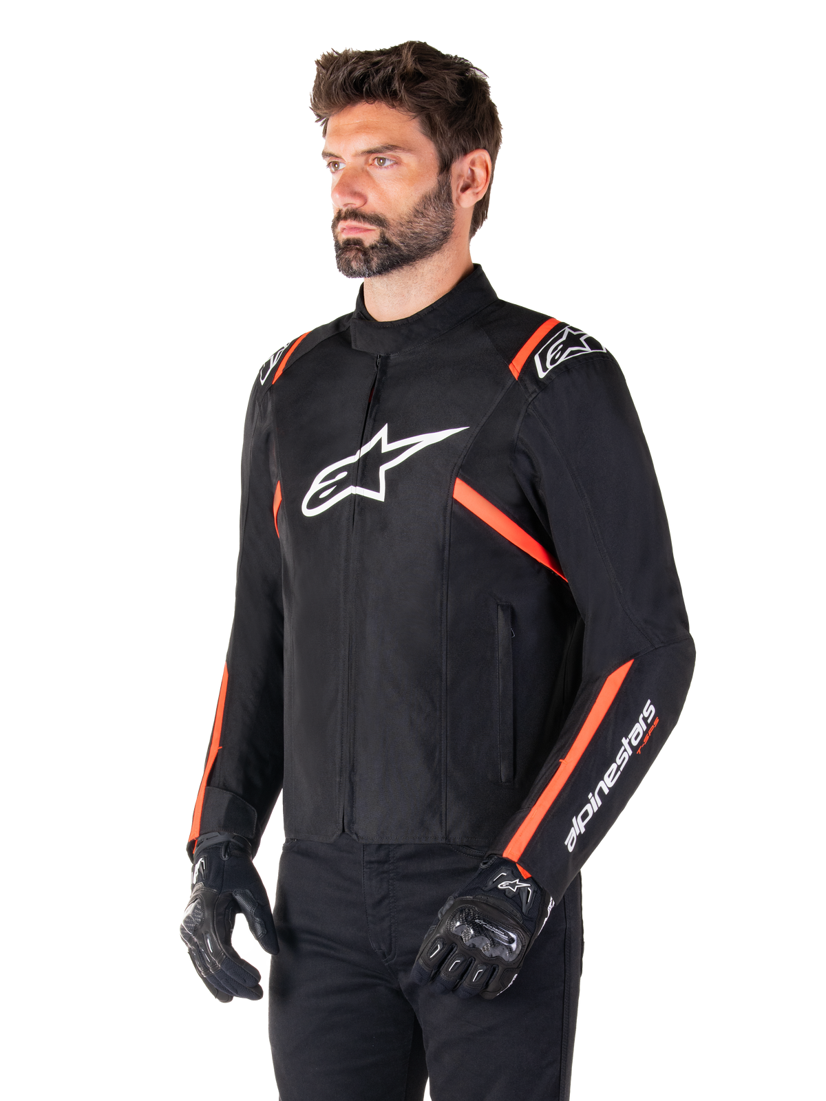 Alpinestars T-SPS V2 vattentät jacka, svart, vit och fluorescerande röd, bärs av en manlig modell med svarta handskar och byxor, med en vit Alpinestars-logotyp på bröstet och fluorescerande röda detaljer på axlar och ärmar, sportig textildesign