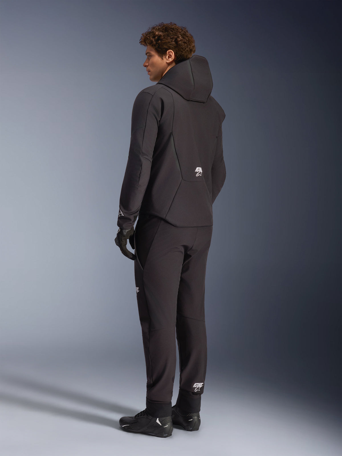 Alpinestars Aeroshell vattentät jacka, motorcykelhoodie för herrar, svart textil softshell, ryggvy på modell.