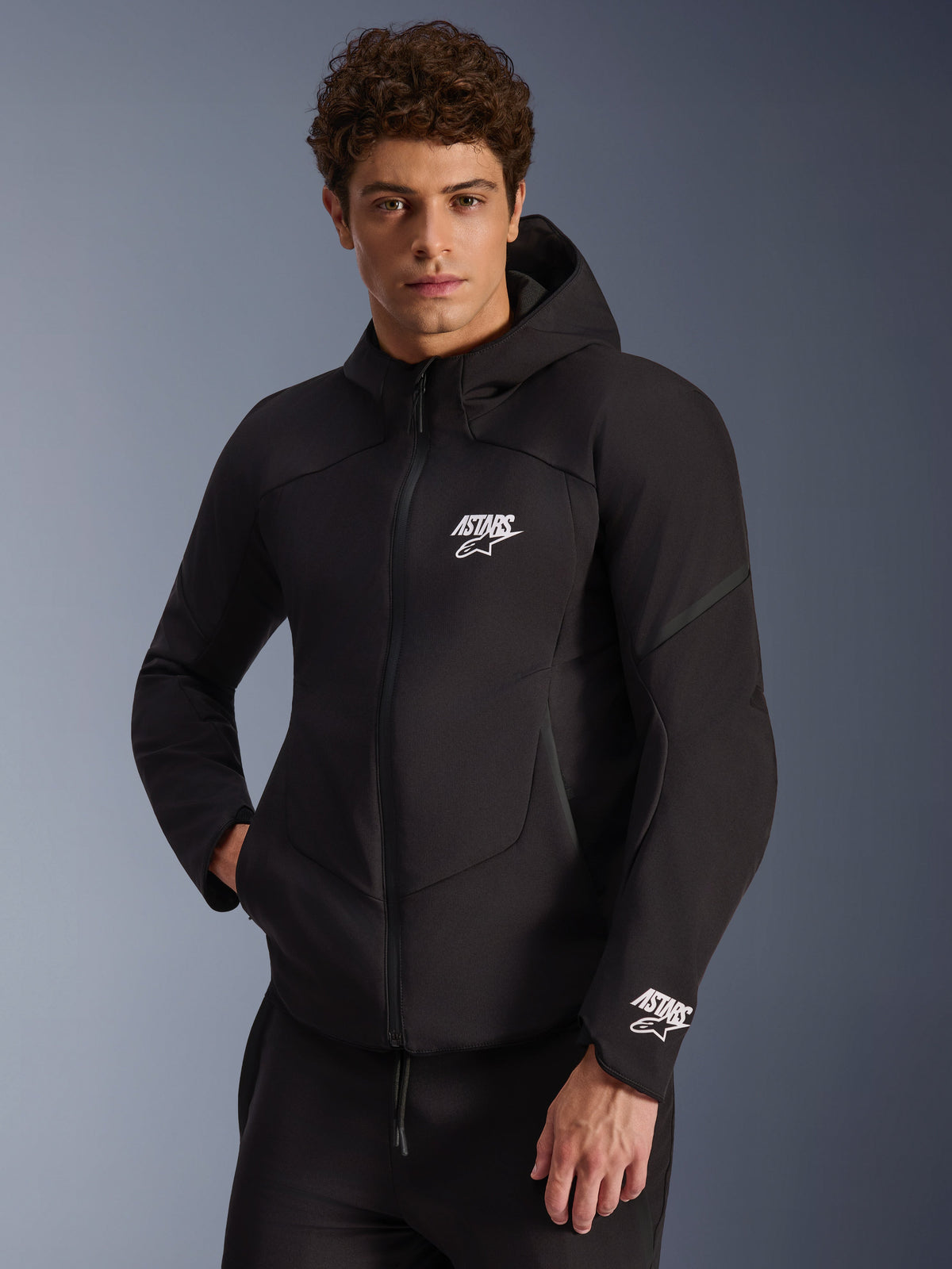 Alpinestars Aeroshell vattentät jacka, herrmotorcykeljacka i svart softshell med vita ASTARS-logotyper och integrerad huva.
