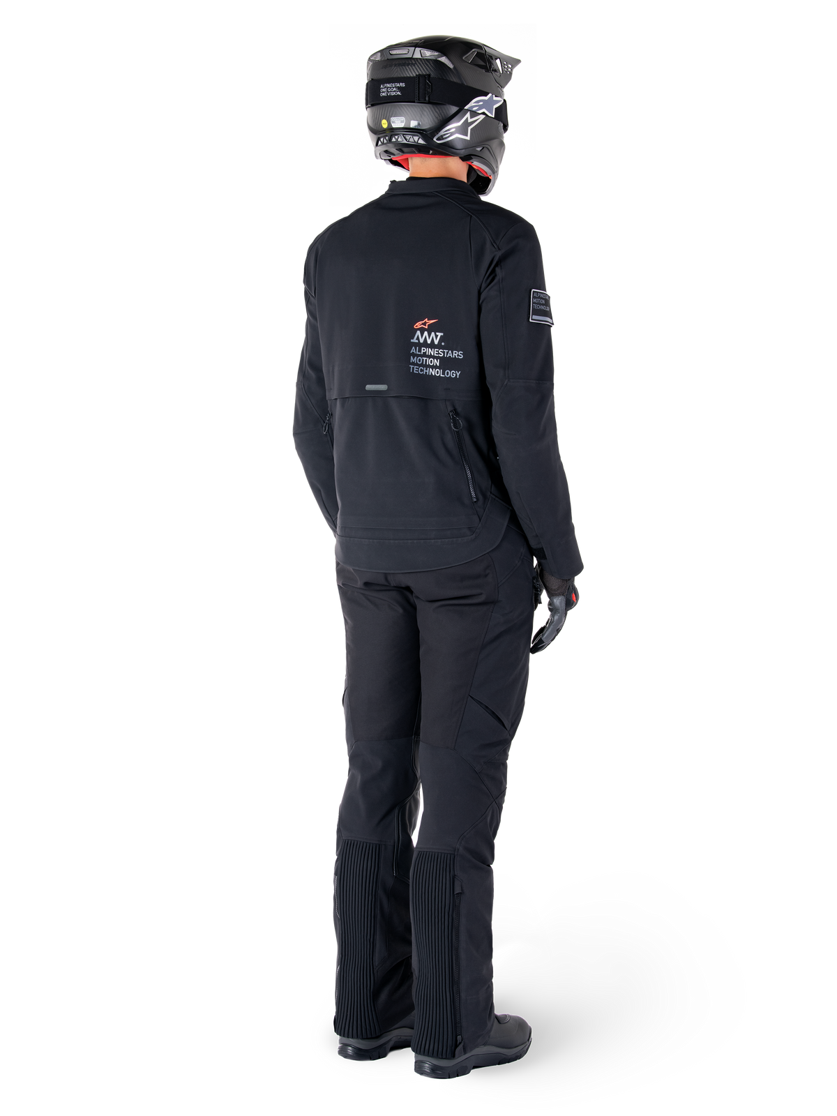 Alpinestars AMT-8 Stretch Drystar® XF Jacket, Black, rear view of a rider wearing the jacket with matching black pants and a black helmet, featuring 'Alpinestars Motion Technology' branding on the back, technical stretch material for adventure motorcycle riding