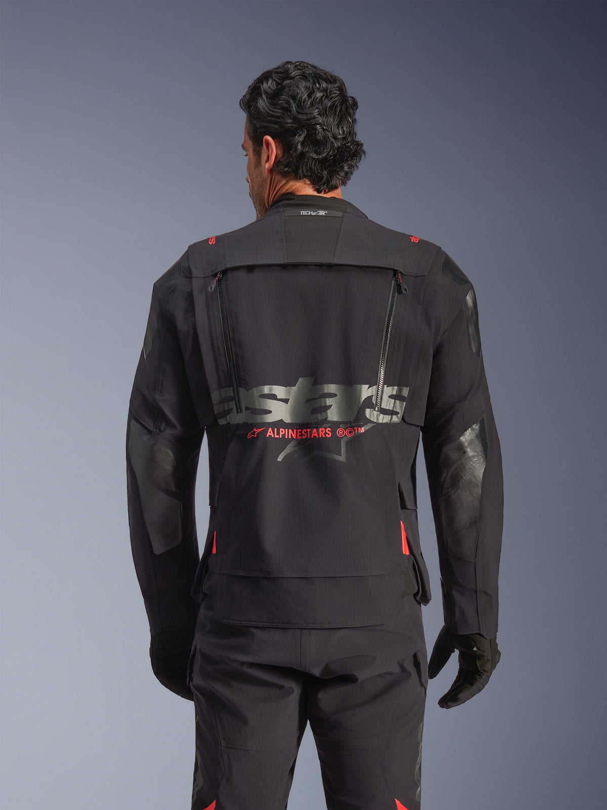 Alpinestars Halo Pro Drystar® XF laminerad jacka i Black Dark Shadow, vy bakifrån på modell, teknisk ventilationspanel på ryggen med dragkedjor, röda Alpinestars-logodetaljer och Tech-Air®-märkning i nacken, modulär äventyrsutrustning.