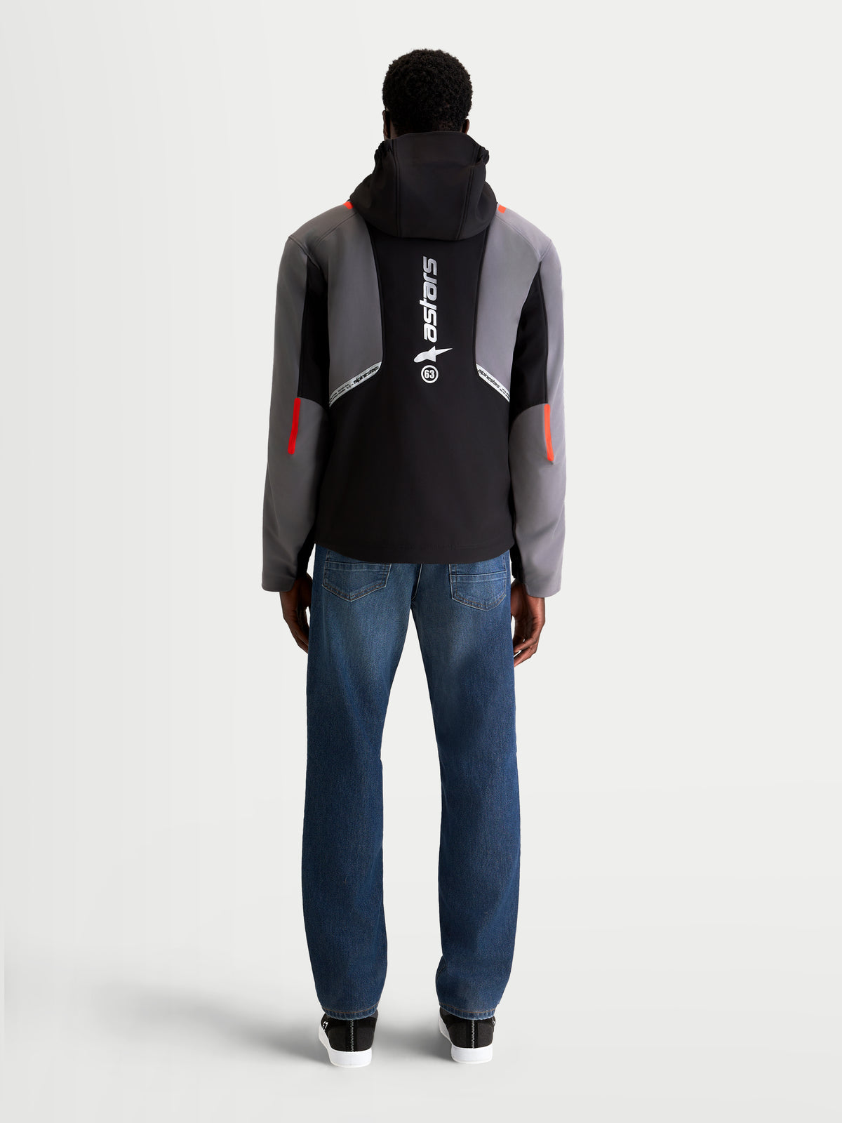 Alpinestars C-5 Drystar Jacket, men's urban contemporary motorcycle textile jacket in black and dark gray, rear view on a model wearing jeans, showing integrated hood and large vertical logo on the back