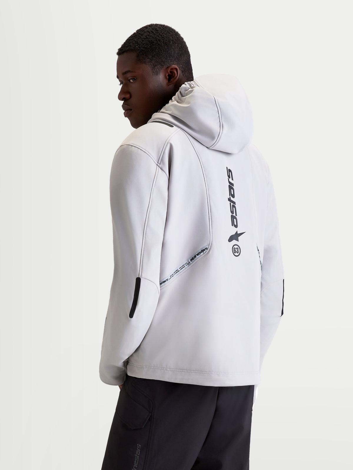 Alpinestars C 5 Drystar jacka, ljusgrå och svart motorcykeljacka för herr, vy bakifrån som visar integrerad huva, softshell-konstruktion och vertikala logodetaljer på ryggen på en modell